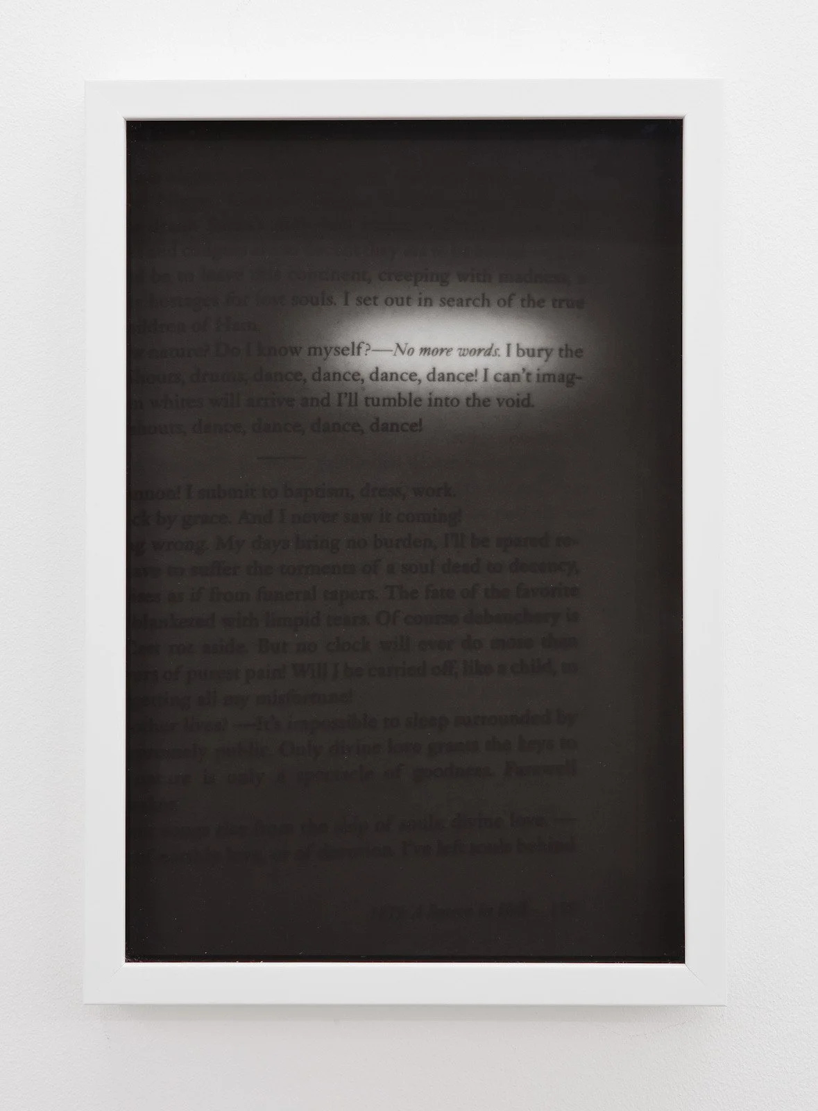 A framed, electronic e-ink style reading device displaying a page of text with some sections blurred or with low contrast, making parts of the text difficult to read.