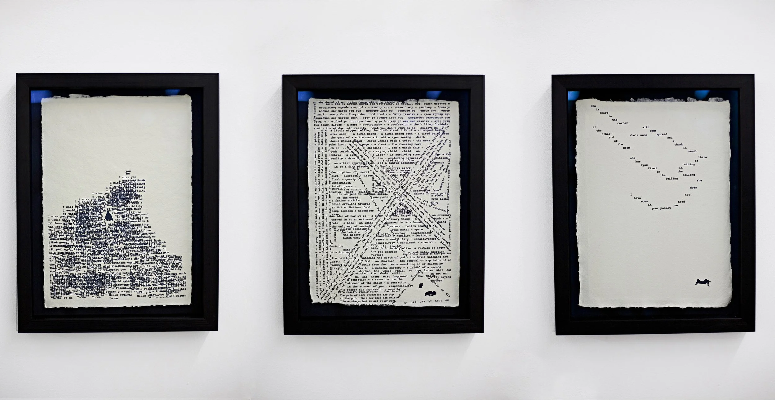 Three framed art pieces featuring text on torn paper backgrounds, arranged side by side on a white gallery wall.