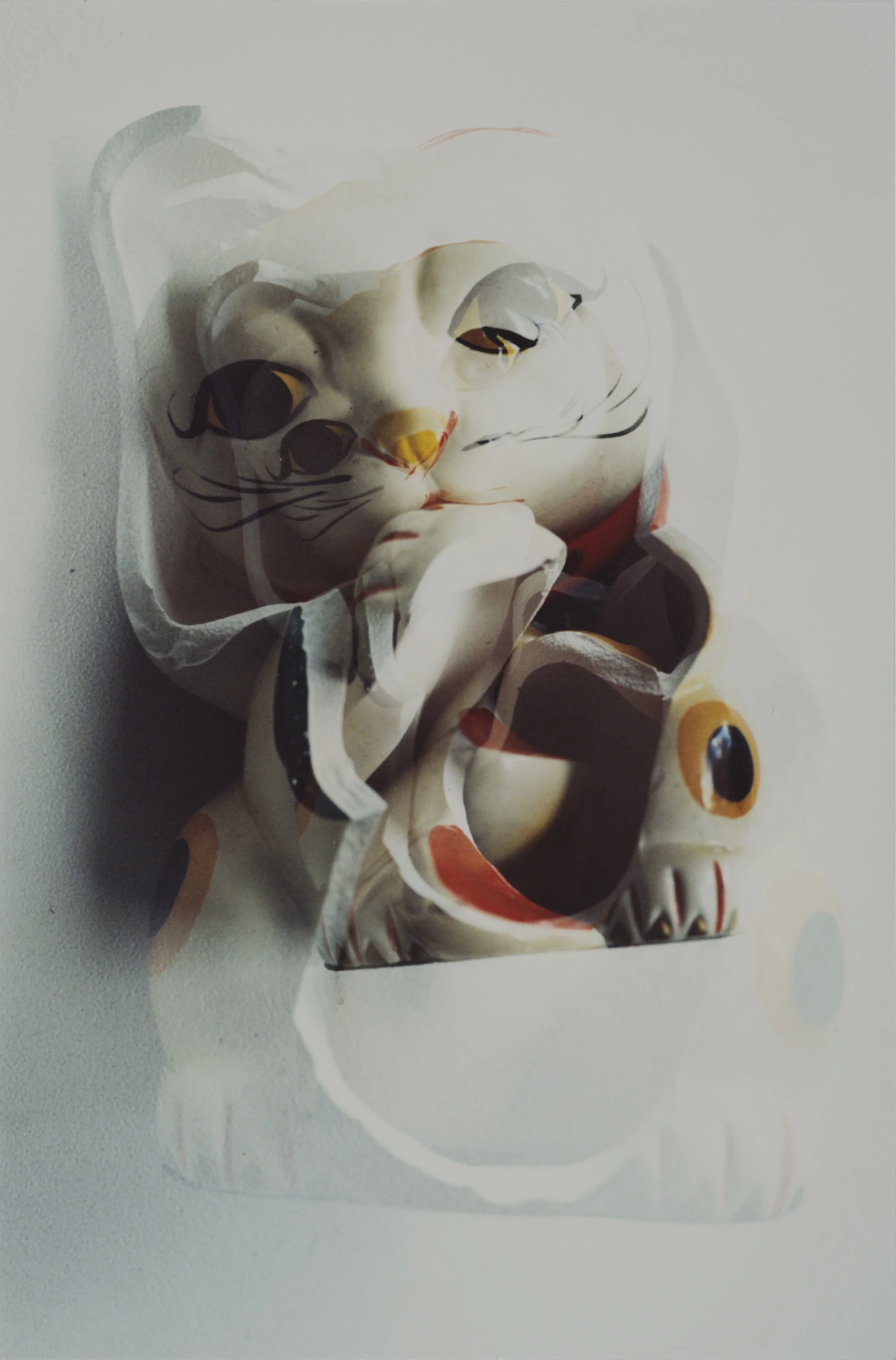 Decorative crushed ceramic figurine of a smiling cat with black eyes, orange accents, and a red collar, placed against a white background.