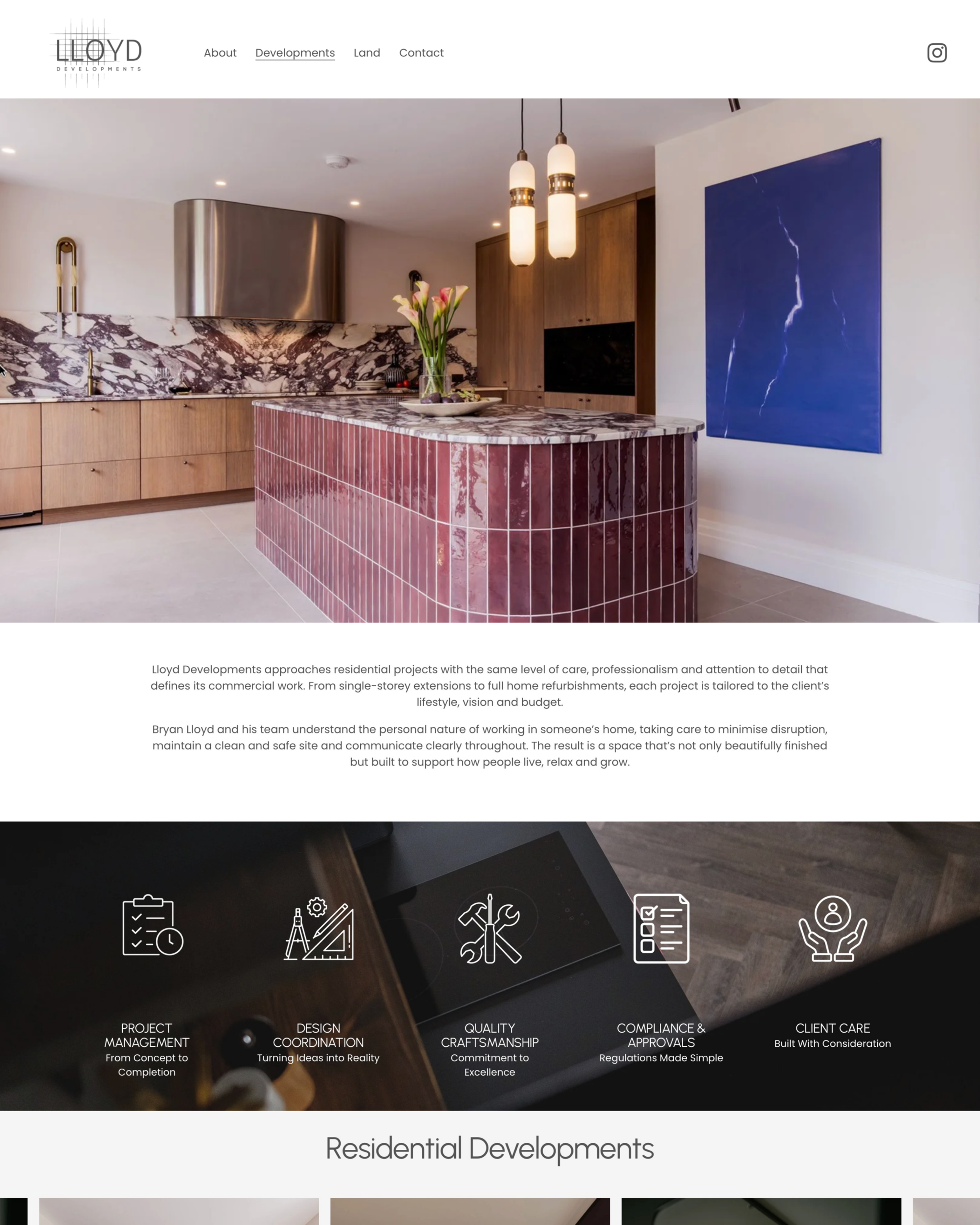 Interior view of a modern kitchen with a marbled backsplash, wooden cabinets, and a marble-topped island with red tiles. There are pendant lights and a blue abstract painting on the wall.