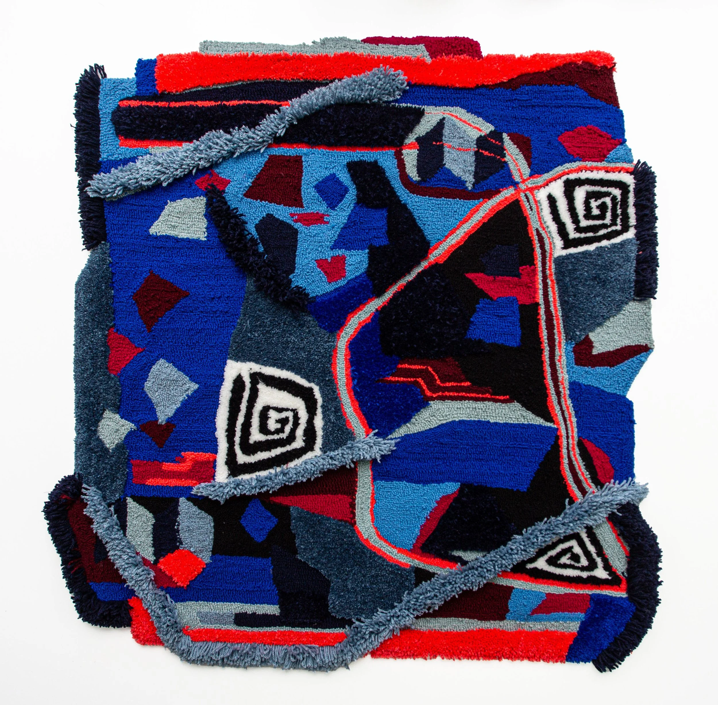 Colorful, abstract patterned woven rug with red, blue, black, gray, and white geometric shapes and designs.
