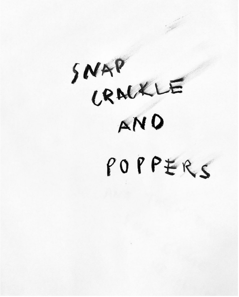 Handwritten words on paper say: 'SNAP CRACKLE AND POPPERS' with some smudges and shadows.