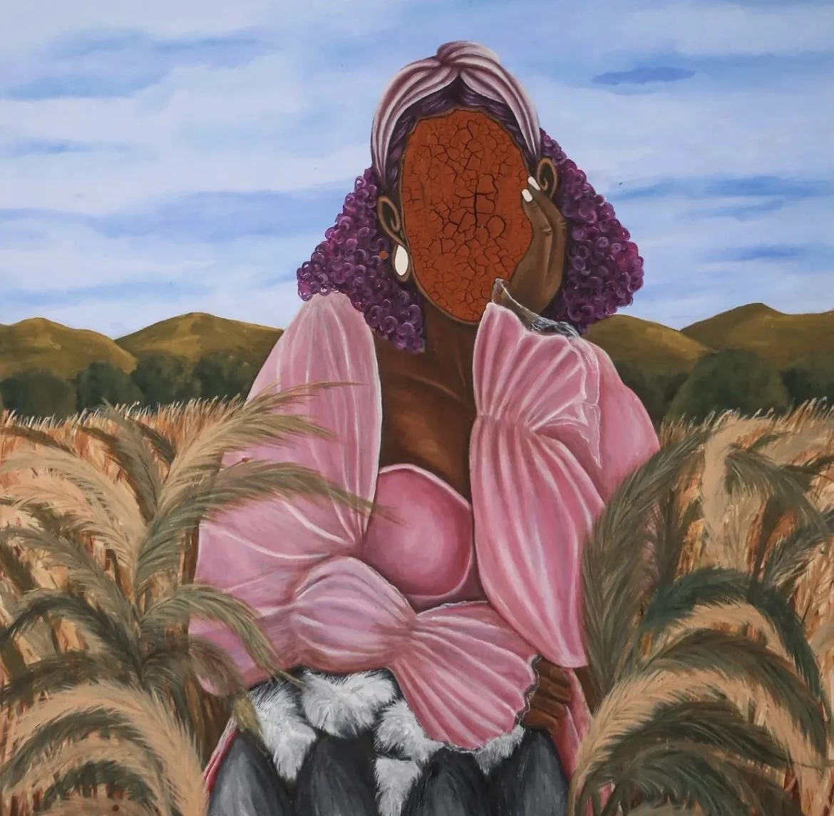 A painting of a woman with a cracked, faceless orange mask, purple curly hair, wearing earrings and pink clothing, holding her face in a field of tall grass with hills and a blue sky in the background.