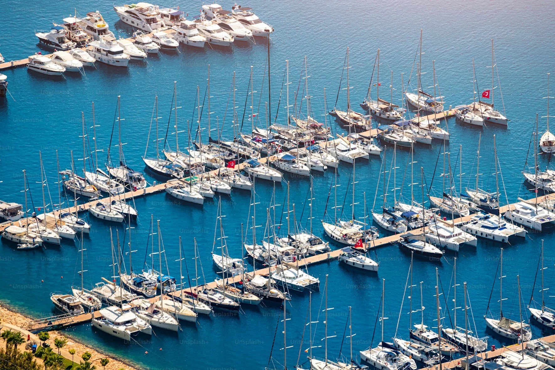 Luxury yacht anchored in a hidden cove near Bodrum, surrounded by untouched turquoise waters, rugged cliffs and secluded beaches accessible only by boat.