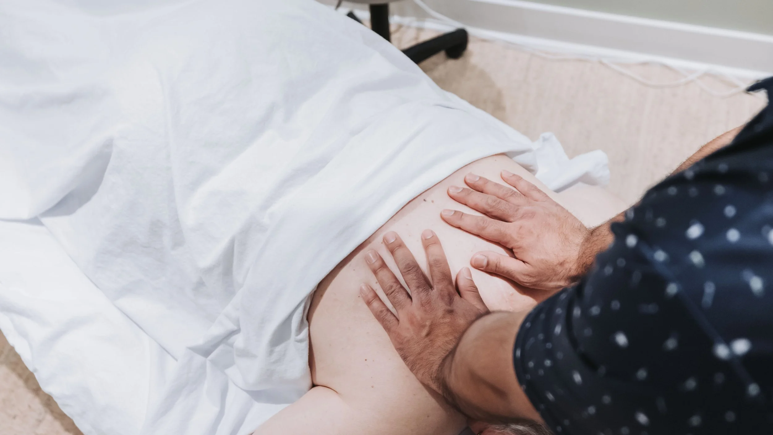Person receiving chiropractic or massage therapy while lying on a treatment table.