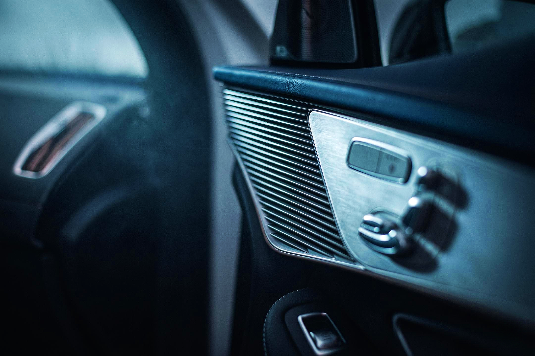 Close-up of a car interior dashboard, featuring metallic and black control panels and vents of a  Mercedes Eqc 400.