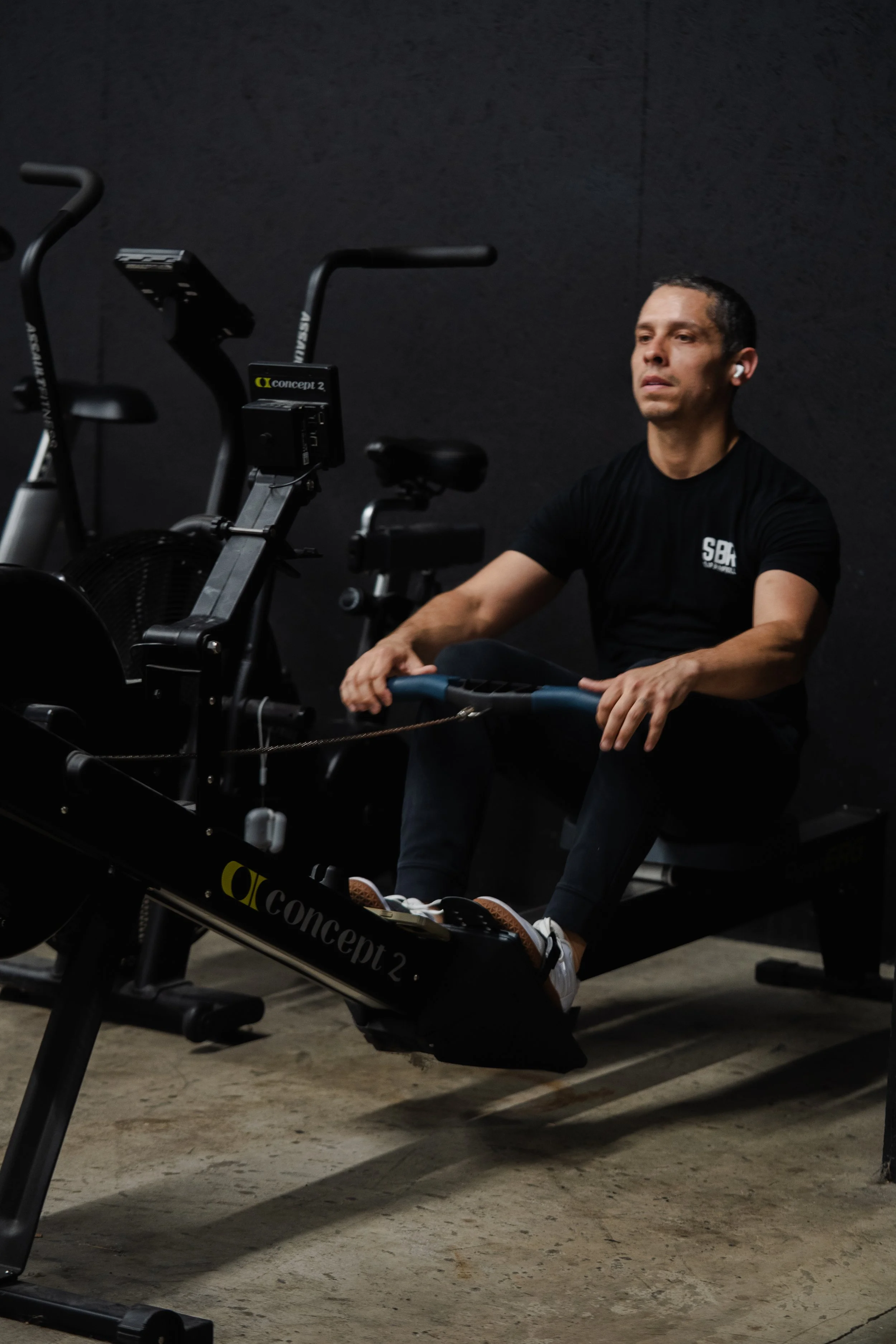 Member rowing during balance and core training at The Foundry Barbell in Greenville, NC