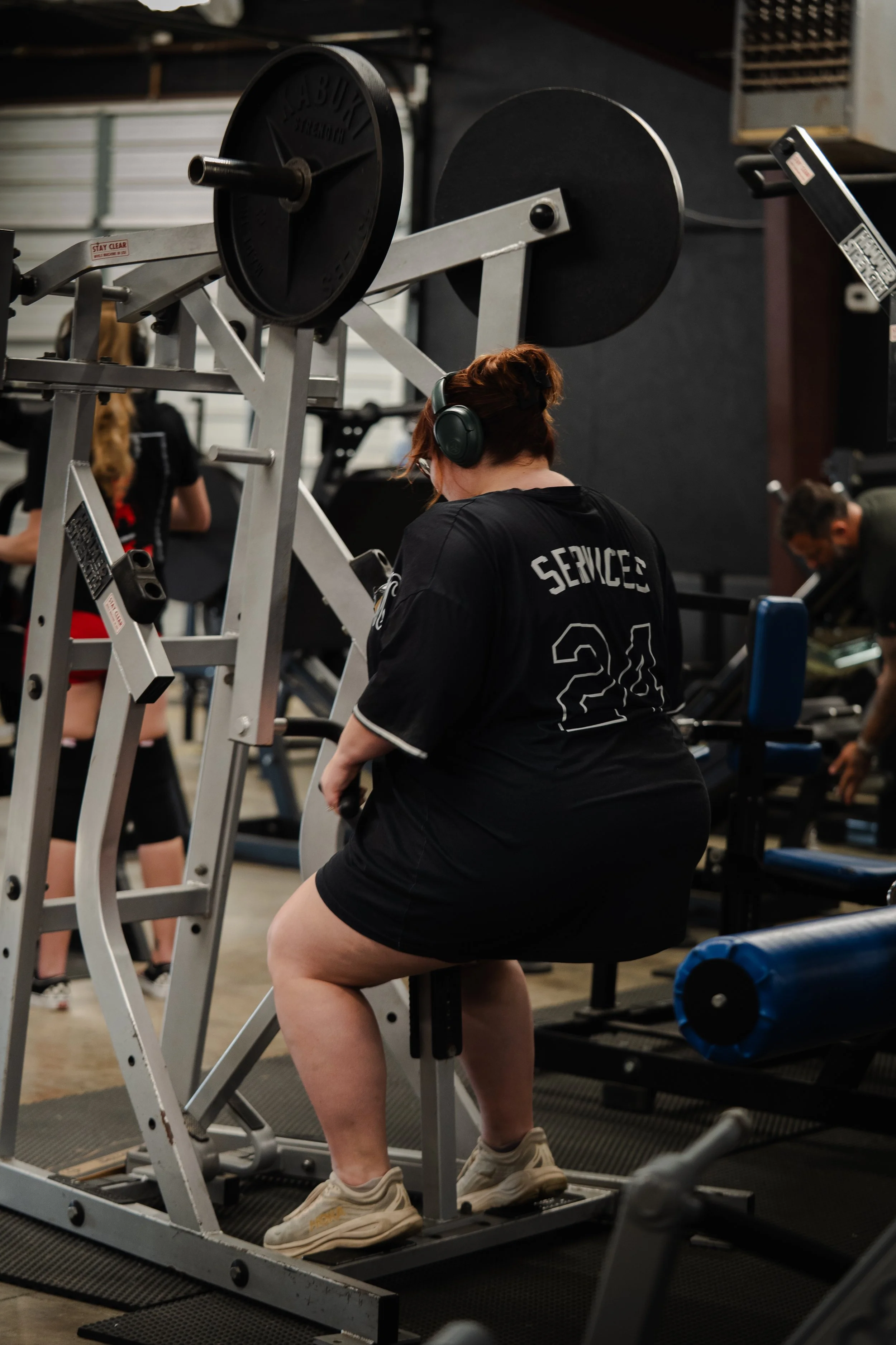 Member training on a plate-loaded low row at The Foundry Barbell, a strength training gym in Greenville, NC