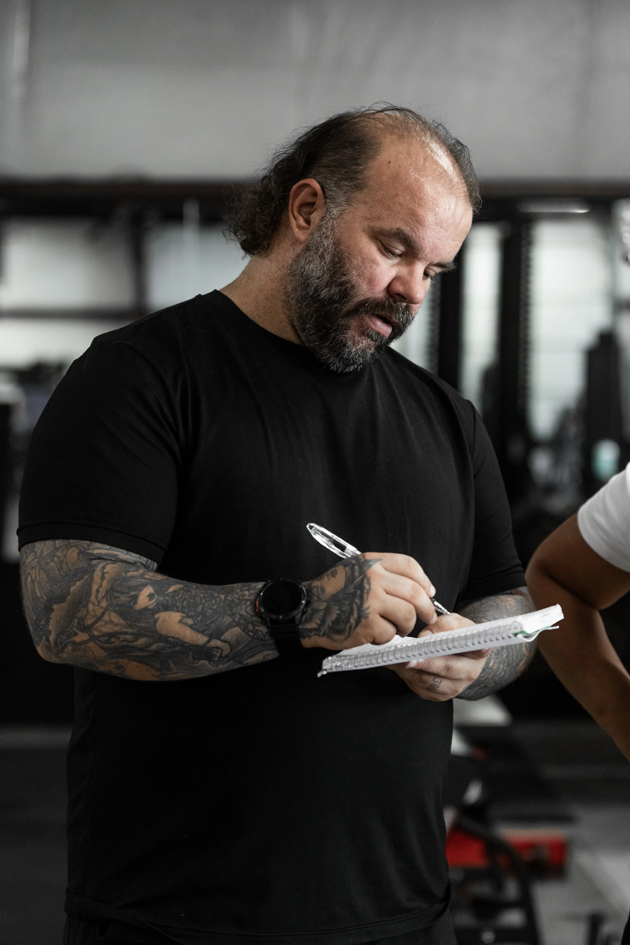 Coach Skyler writing a strength training program at The Foundry Barbell in Greenville, NC