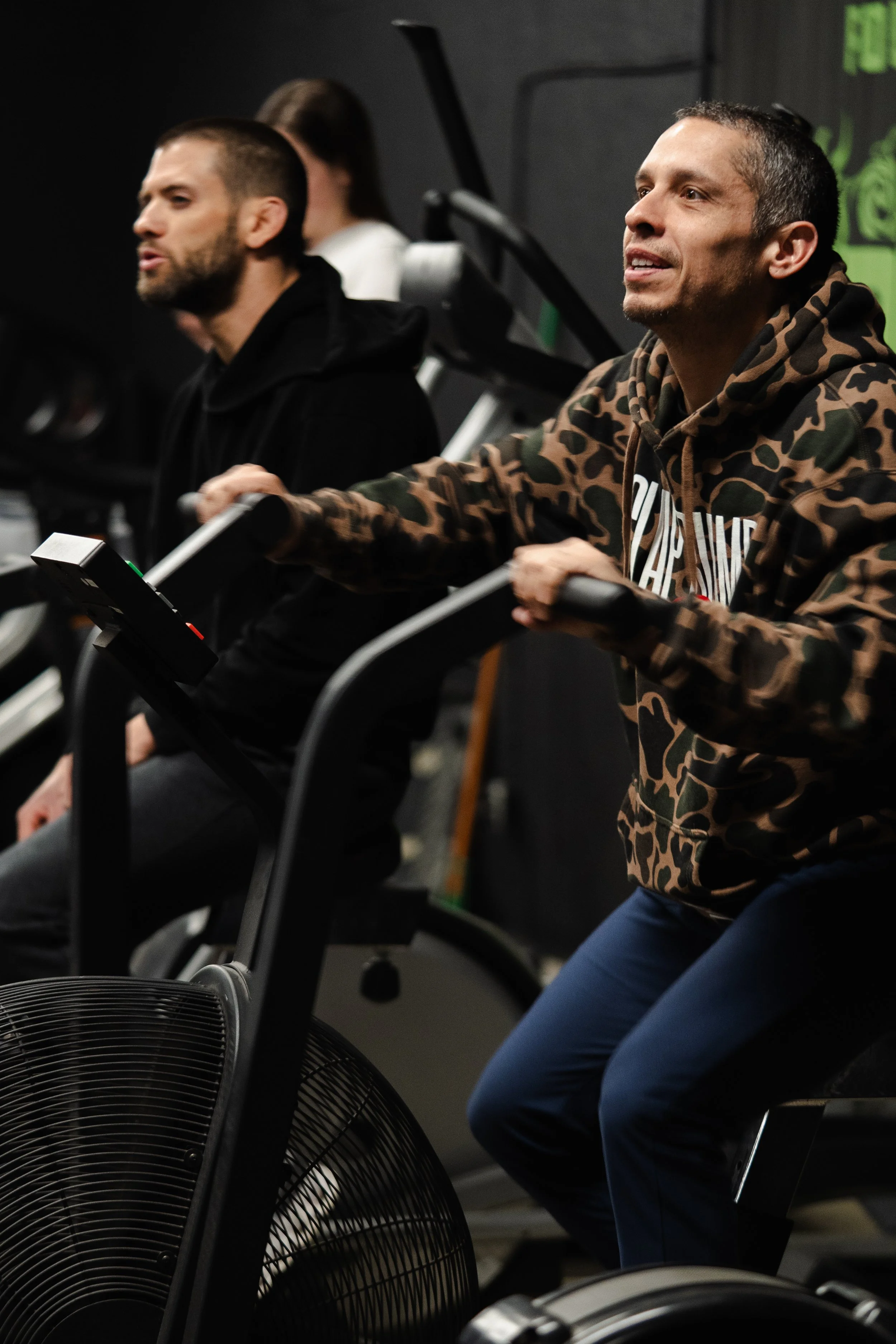 Member training on an air bike during a conditioning workout at The Foundry Barbell in Greenville, NC