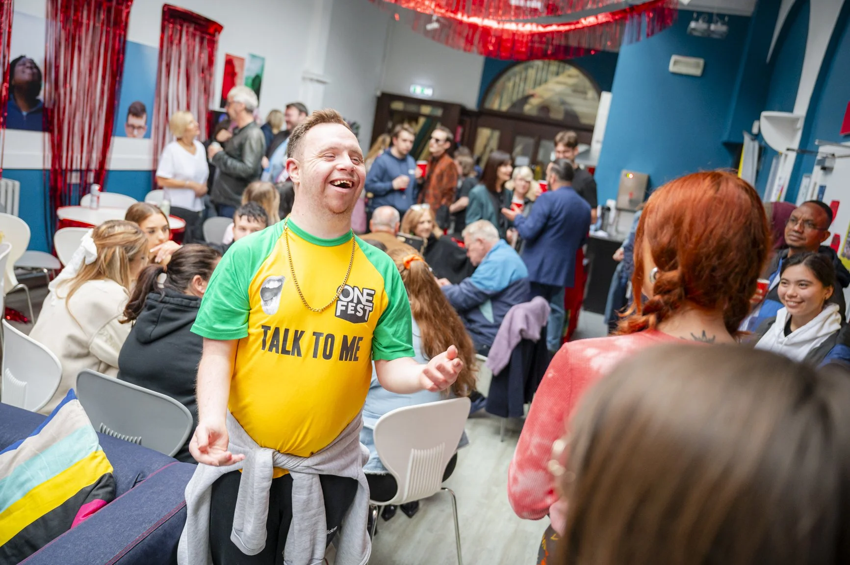Young male with down syndrome smiling in a busy room