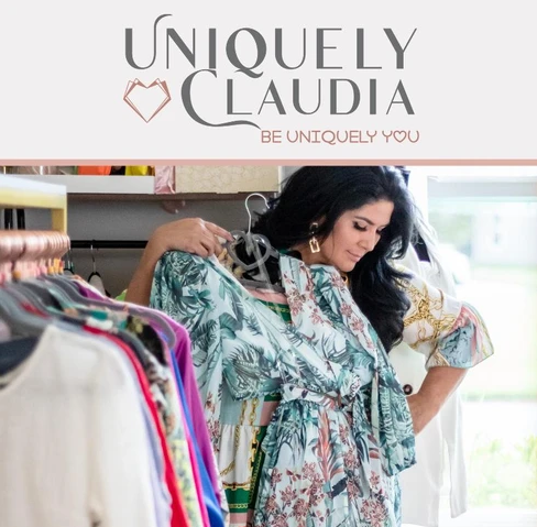 Woman shopping for clothes, holding a floral dress on a hanger in a clothing store.