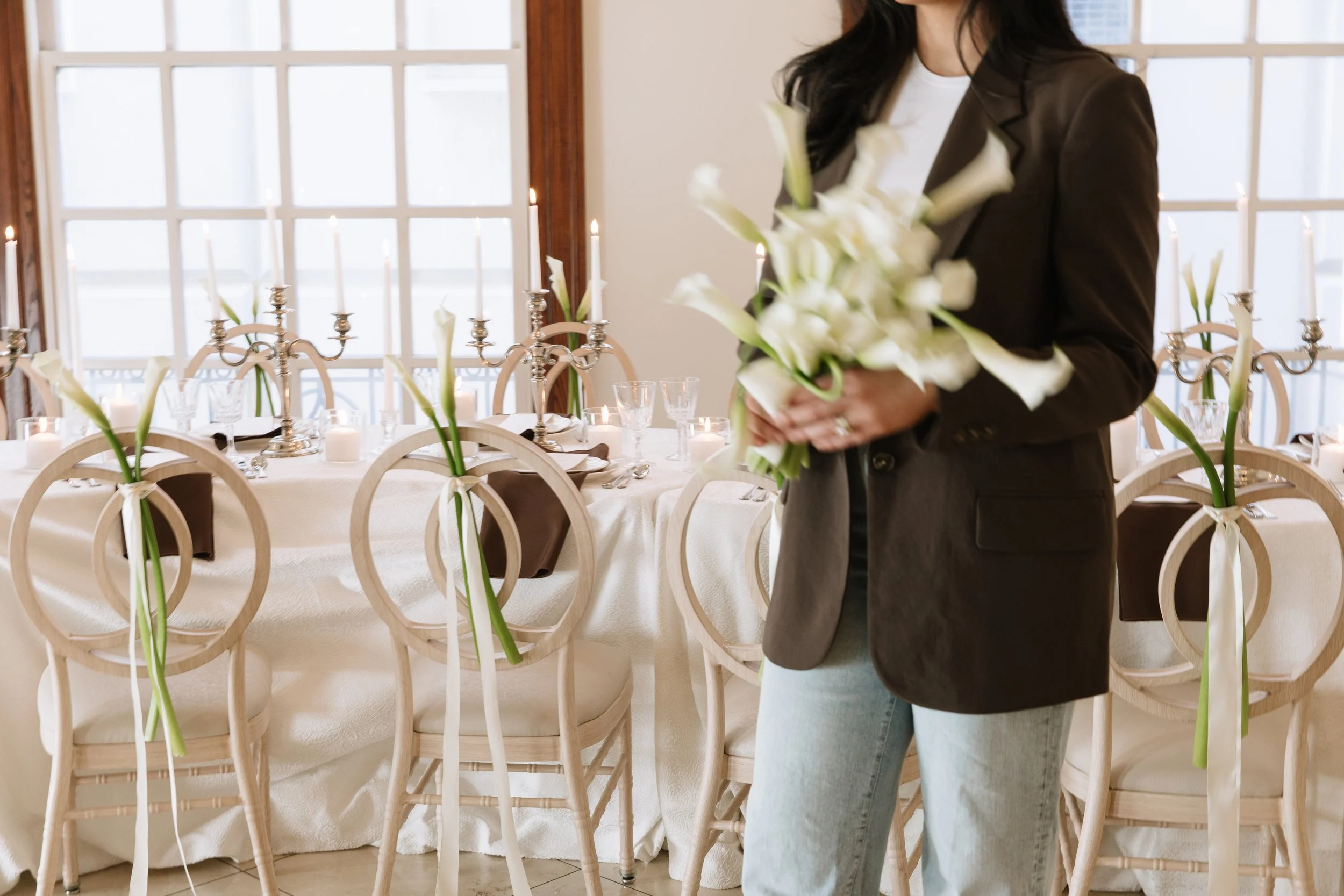 Curated wedding reception setup with floral arrangements, candlelight, and modern table styling