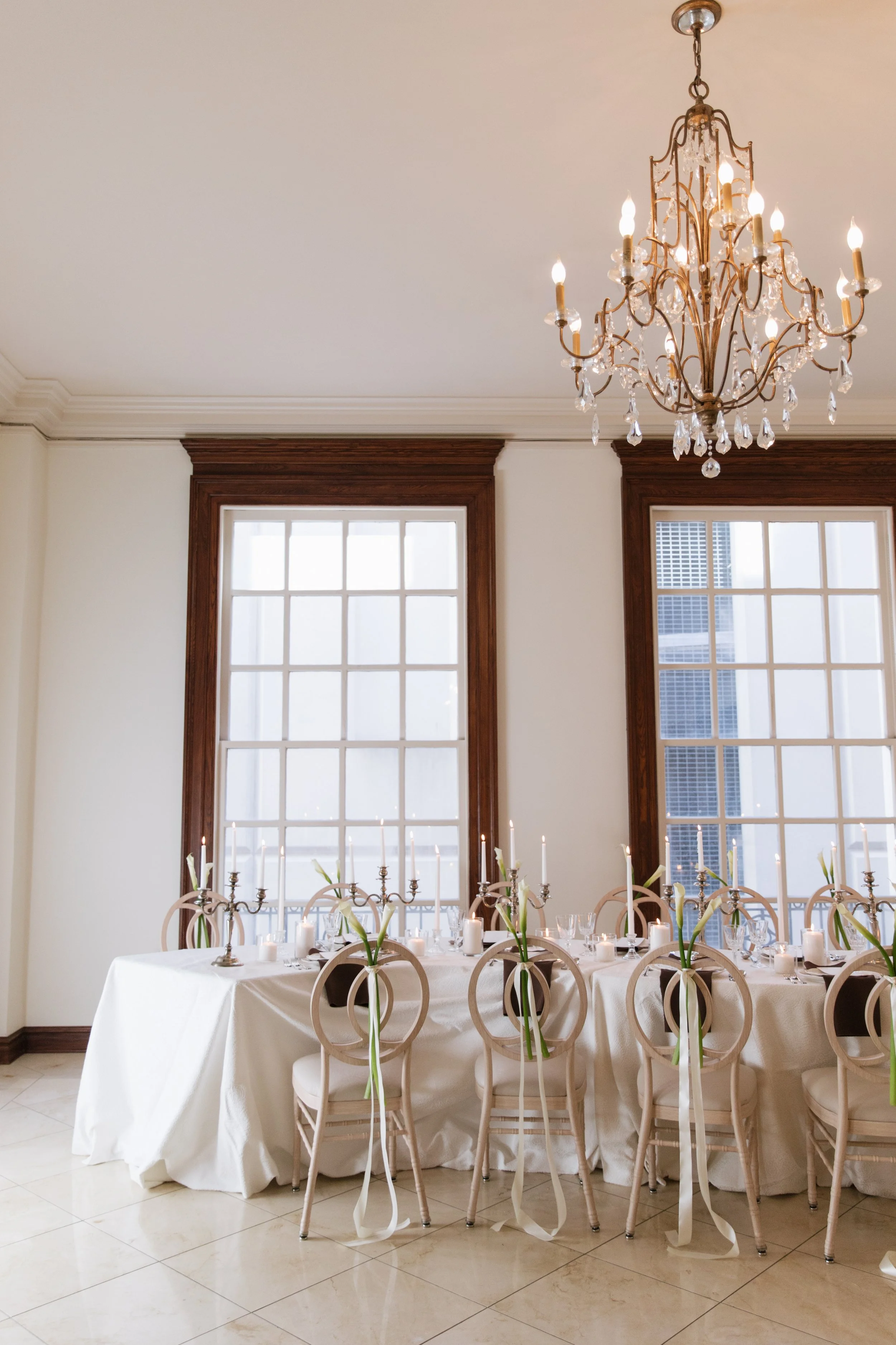 Wedding reception space with chandelier lighting and thoughtfully styled tablescape