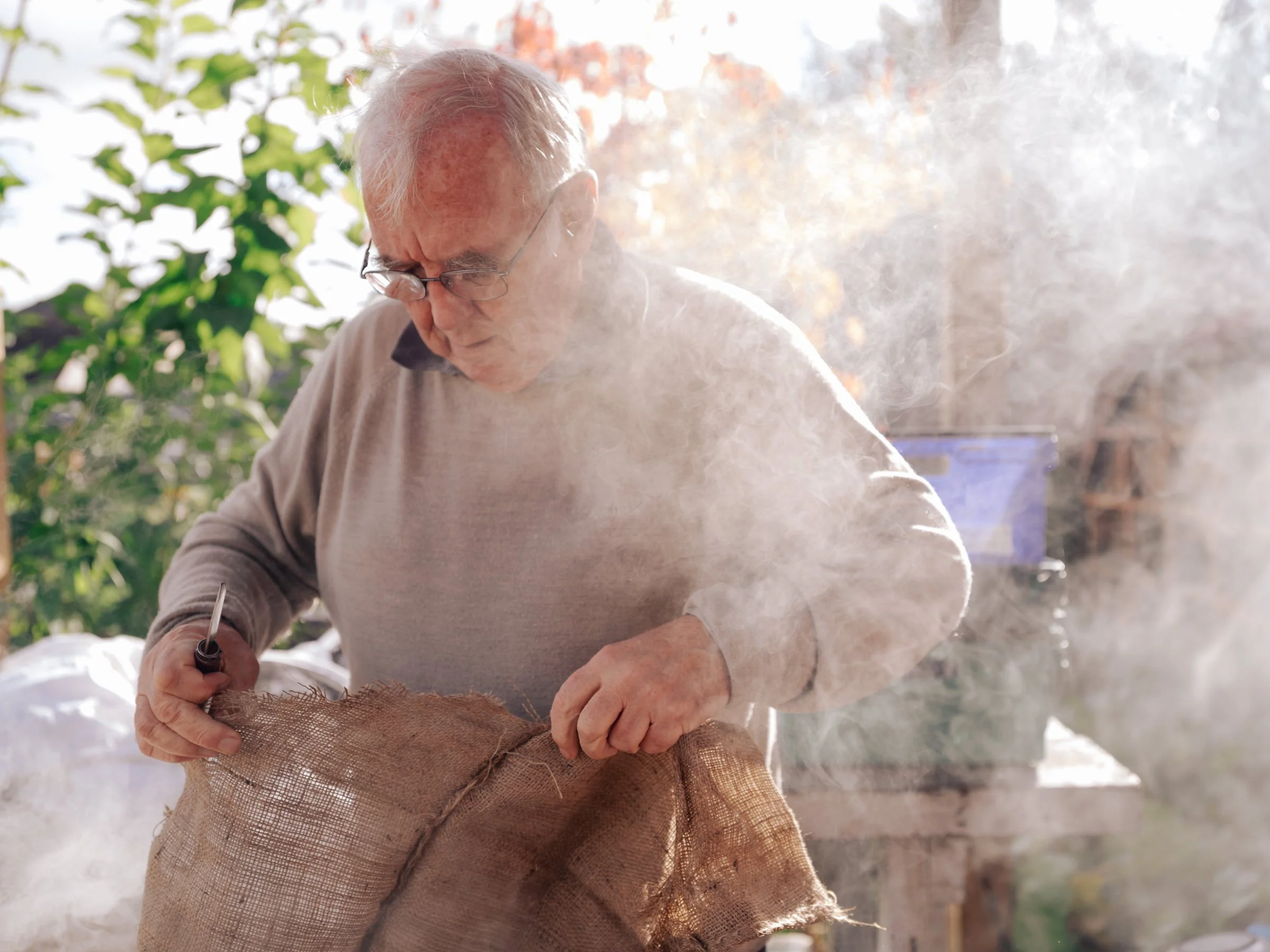 Beekeeper Danny McGee cuts hemp to burn in his smoker, used to calm bees while visiting their hive.