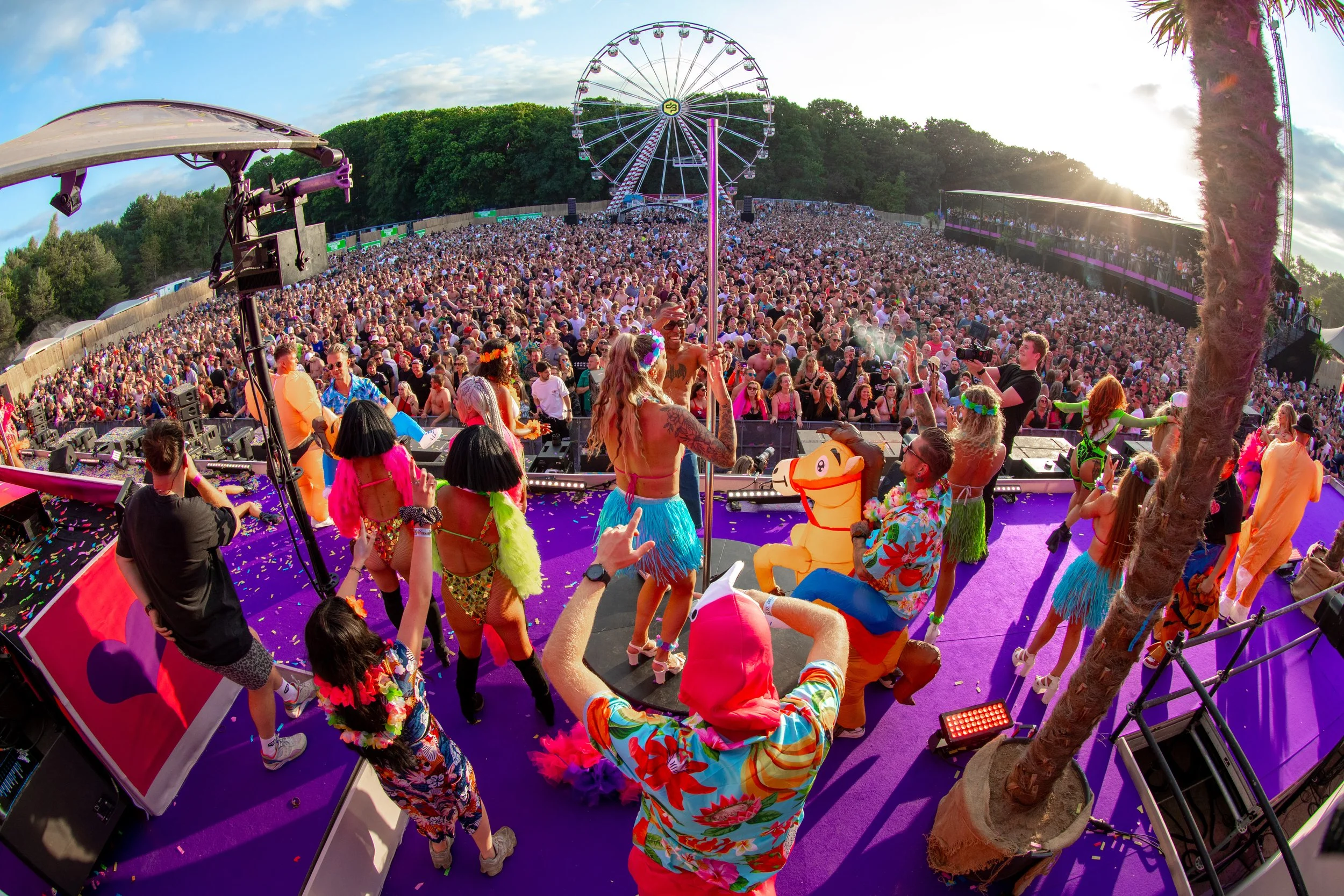 Live entertainment performance op een outdoor festival met dansers en groot publiek.
