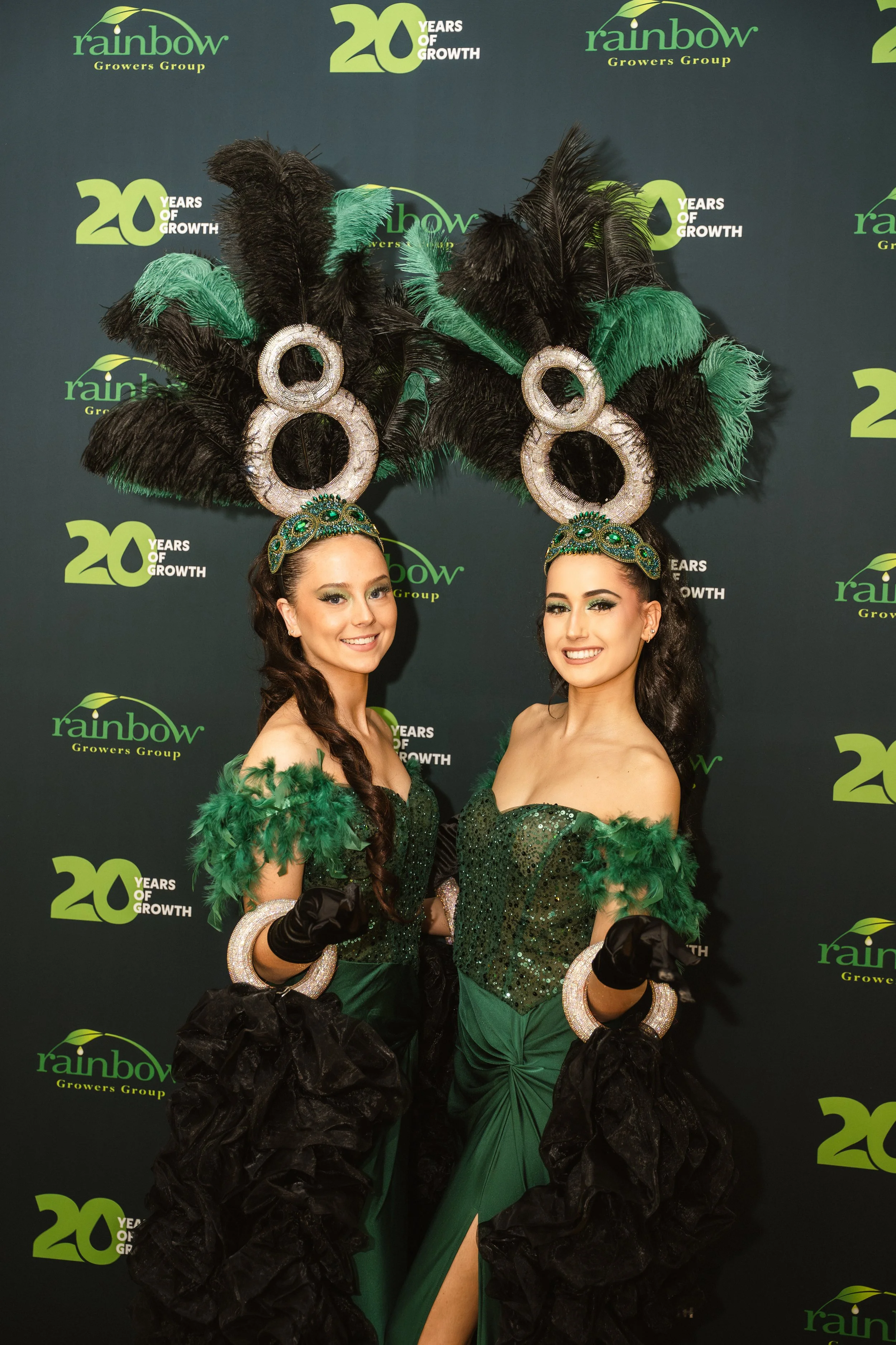 Professionele hostessen in showkostuums met verentooien tijdens een luxueus corporate event entertainment performance.