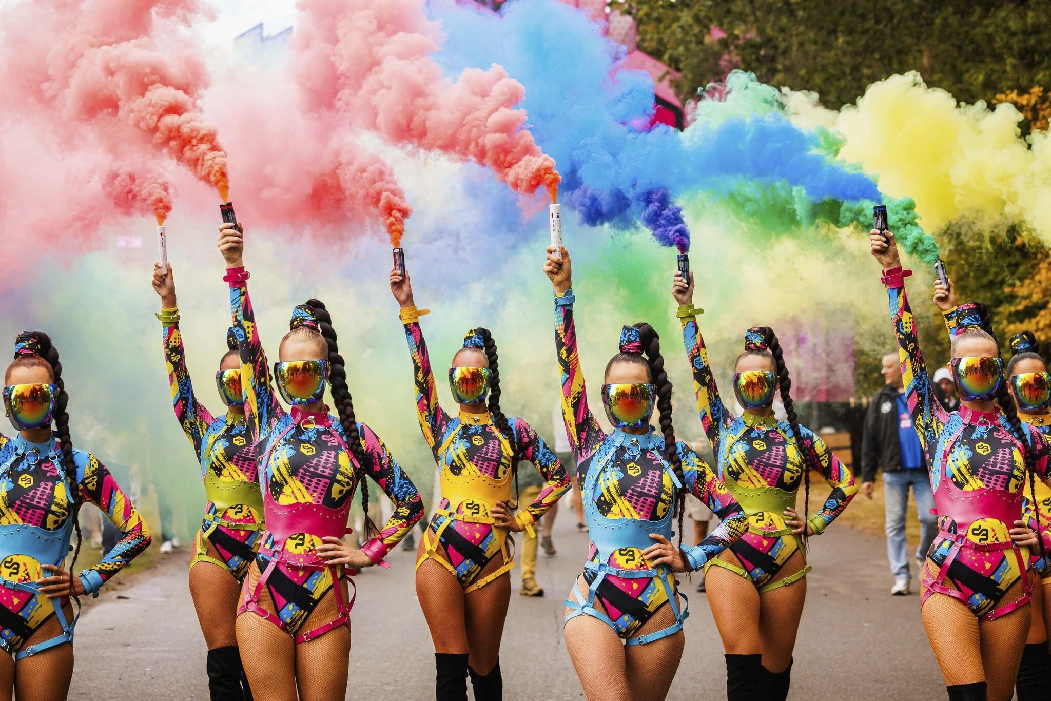 Dansers met gekleurde rookfakkels in kleurrijke kostuums tijdens een festival performance en entertainment show parade.