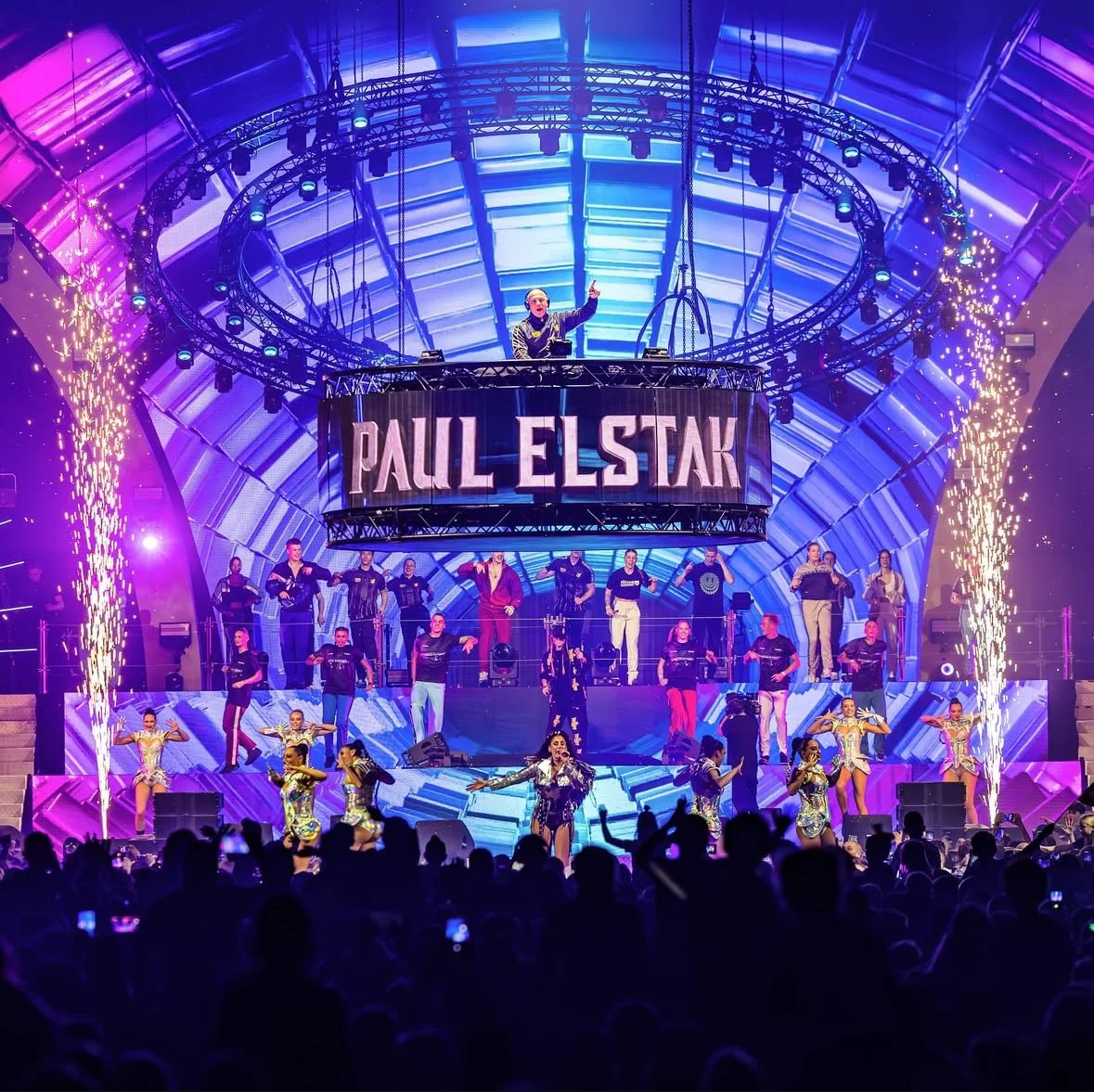 Live show met DJ, dansers en spectaculaire lichteffecten tijdens een groot event in een grote zaal met spectaculaire showcreatie.