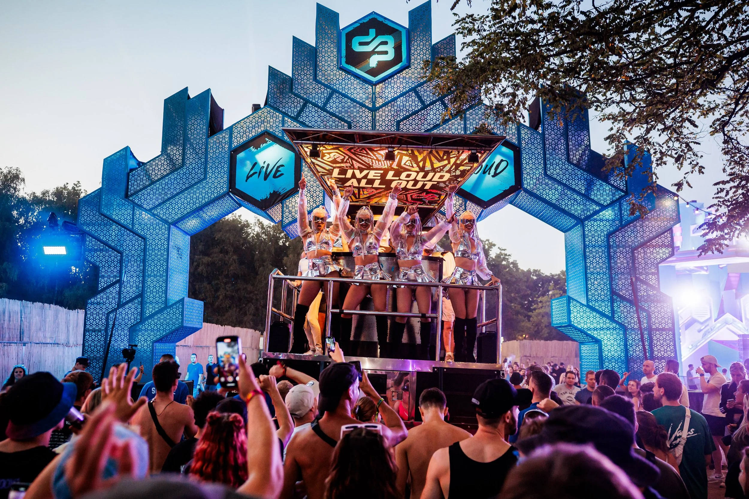 Live entertainment performers op een festival stage tijdens een outdoor event met publiek.