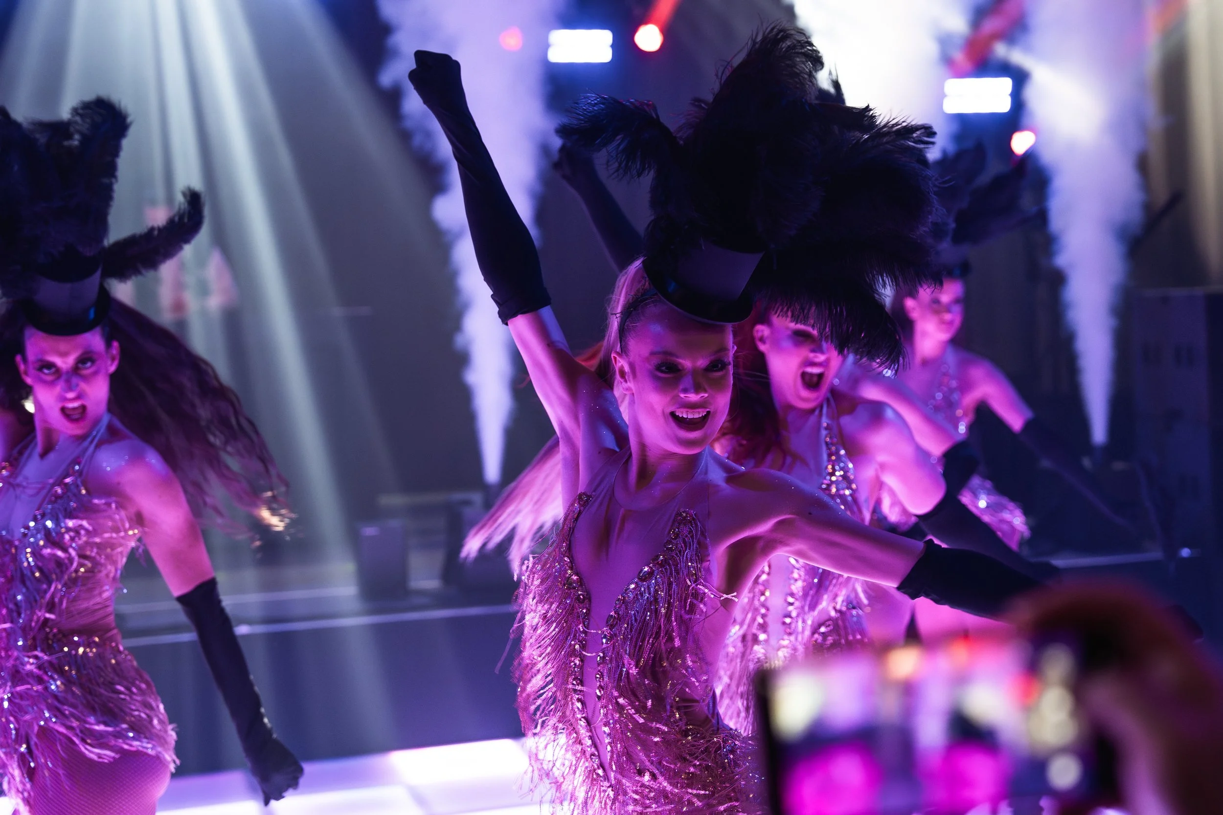 Show danseressen dansen een choreografie op een bedrijfsevenement met verentooien, co2, licht 