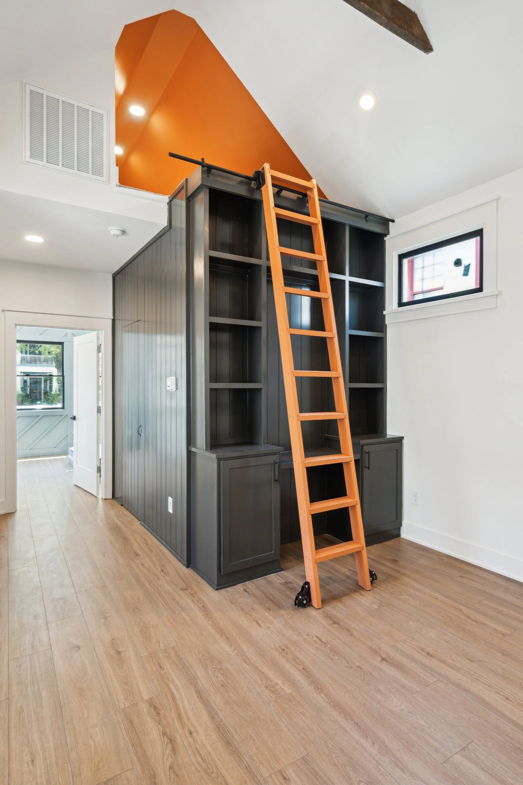 living pace with built in storage and brigtht orange ladder