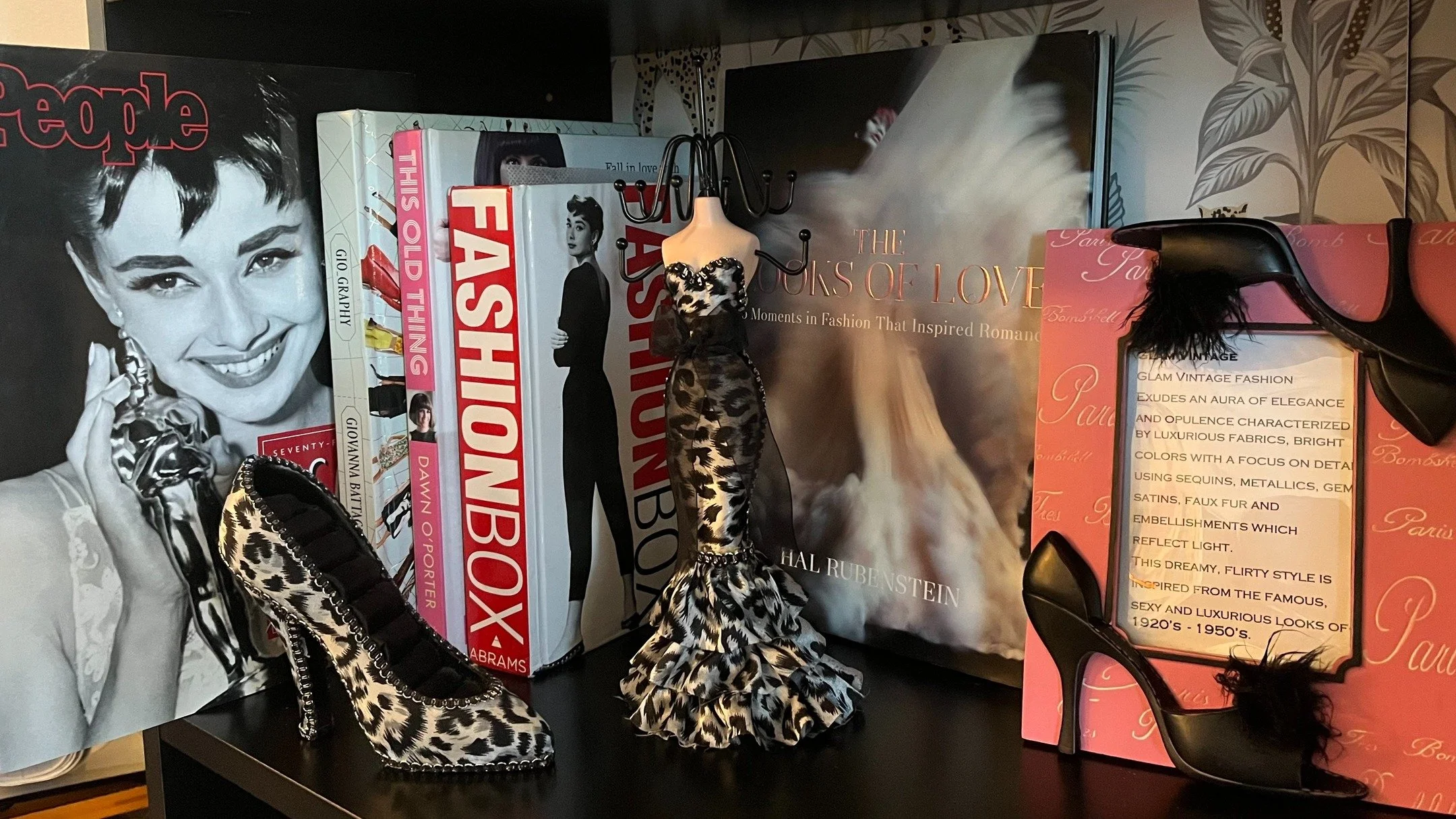 This curated corner brings together the sophistication of Old Hollywood and the chic allure of Parisian style. From the iconic grace of Audrey Hepburn to the high-fashion pages of Megan Hess&rsquo;s Elegance, every detail celebrates the art of being 