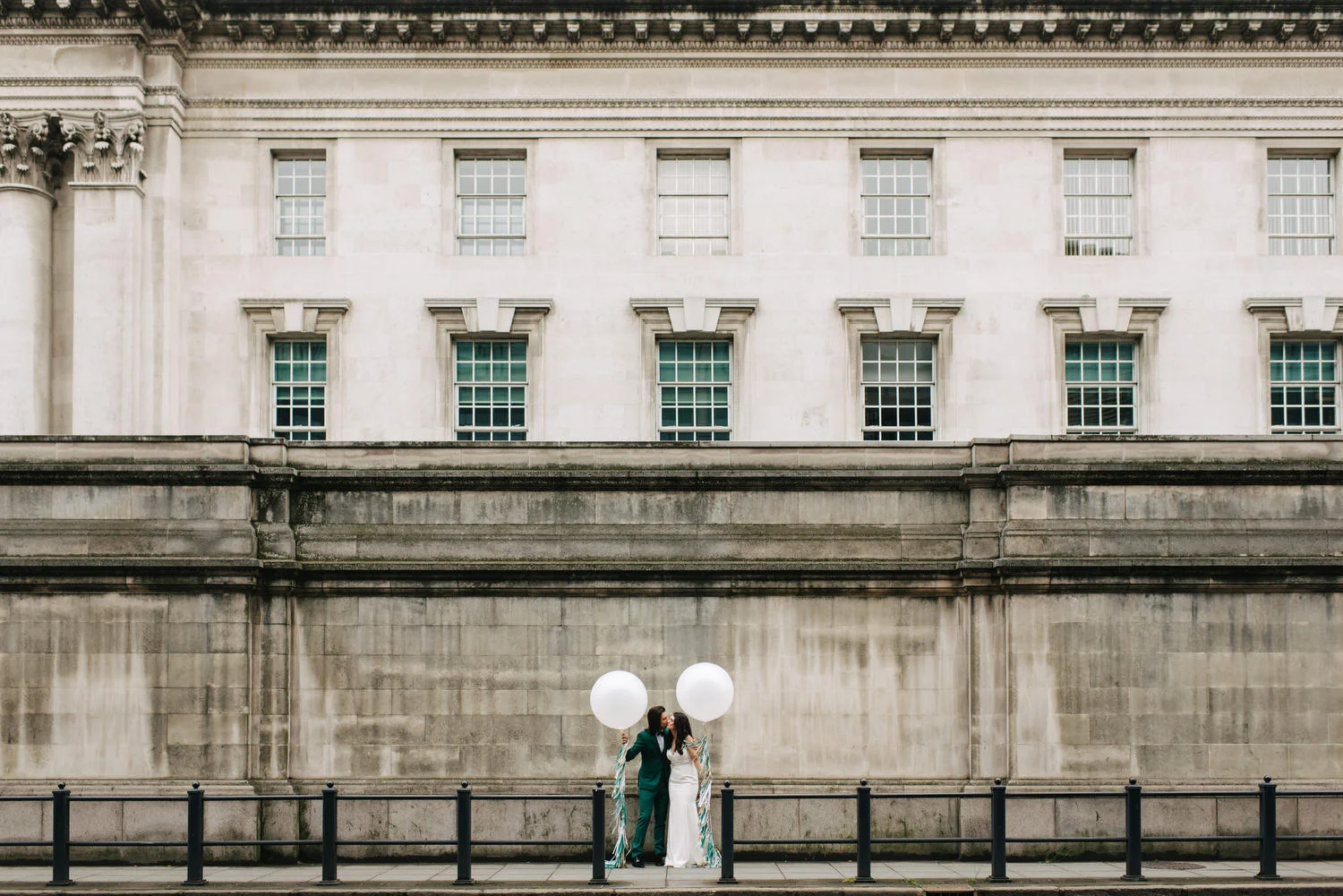 A couple posing with balloons on their wedding in St George's Market Belfast
