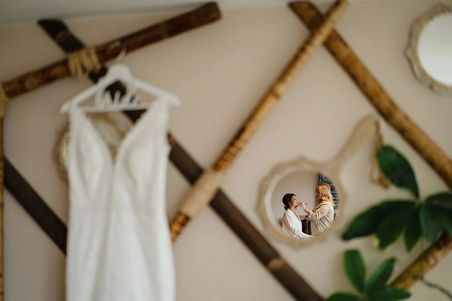 Amazing Photo of a bride getting her makeup done with her dress in background.