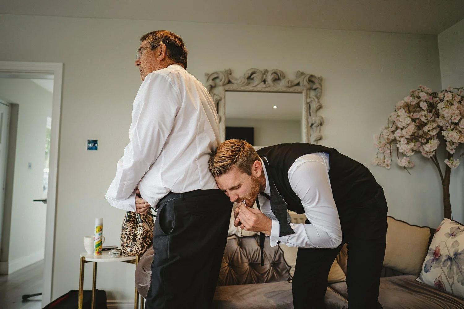 Groom removing tags from suit with his teeth