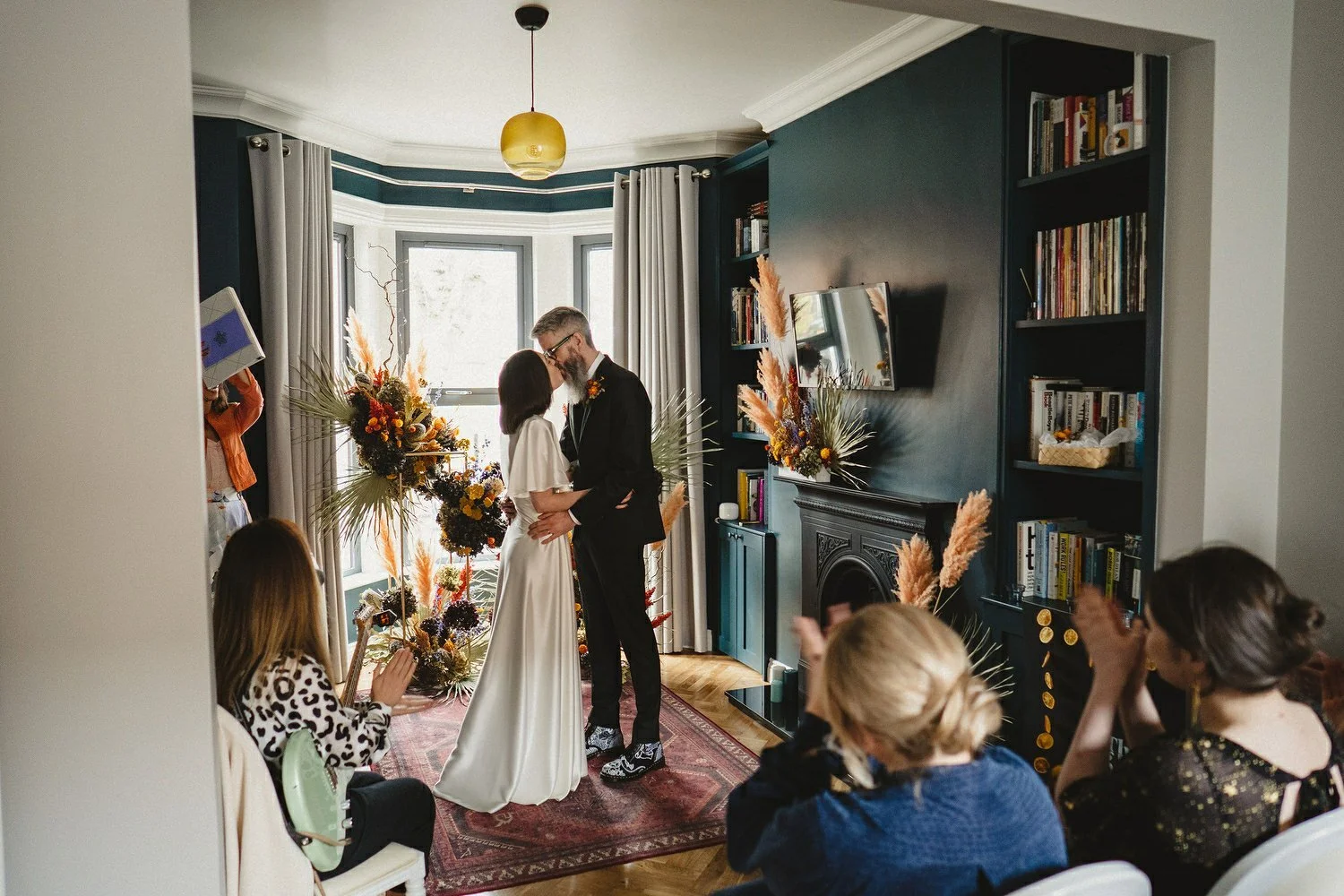 A couple having their first kiss while getting married in their own house
