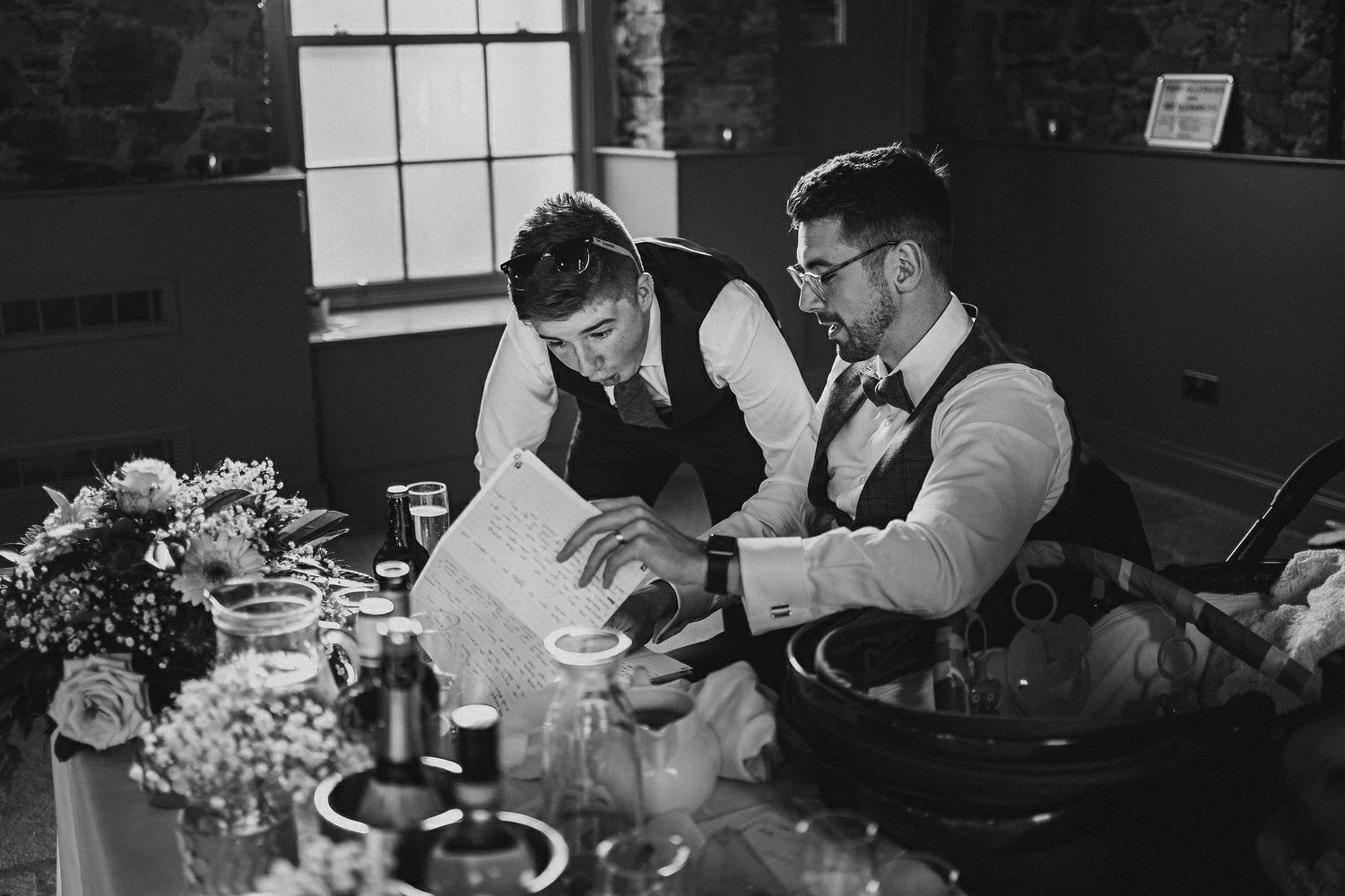 Candid wedding photography of a groom showing his page boy his speech