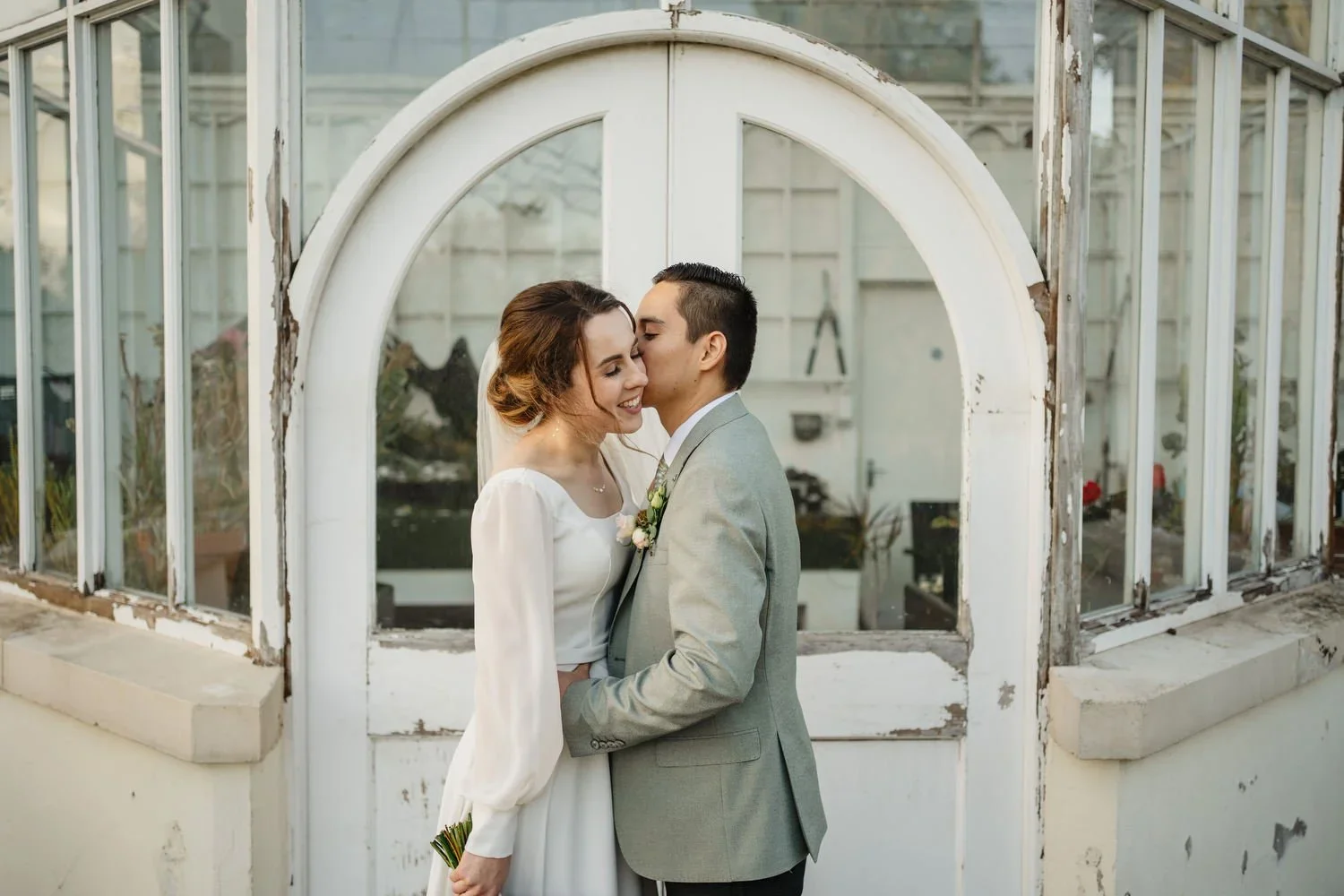 A bride and groom share a kiss at Malone House Wedding venue in South Belfast