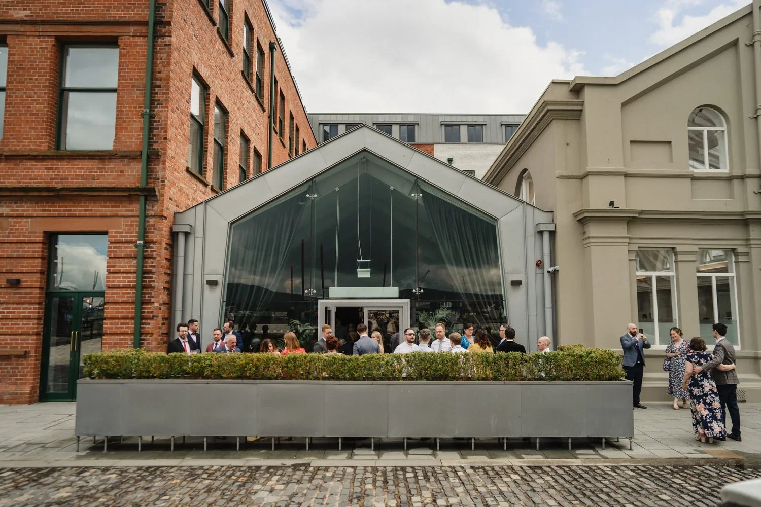 Wedding guests enjoying a drink outside the cocktail bar at Titanic Hotel Belfast