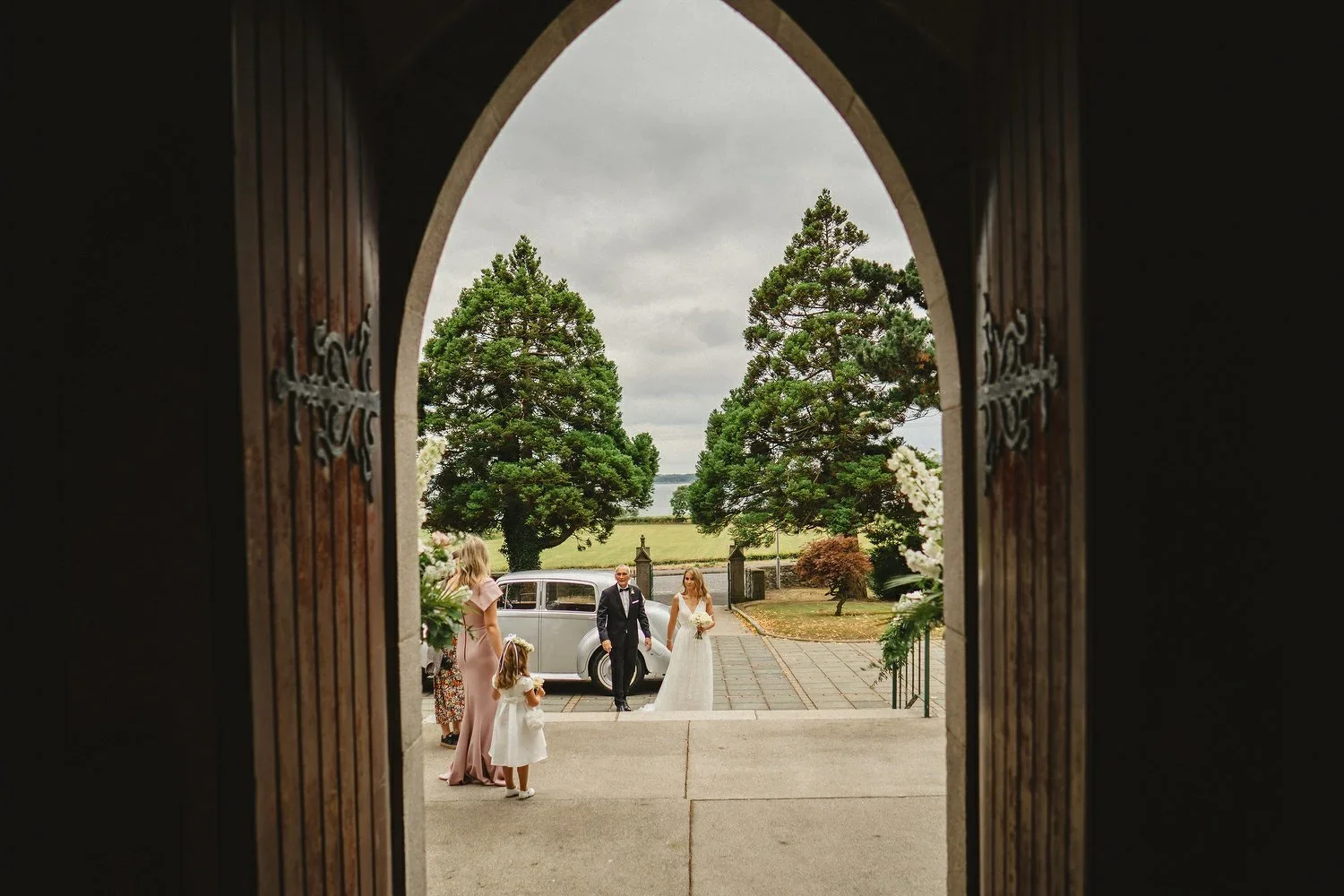 A Bride and her Dad arrive at the church for a wedding.