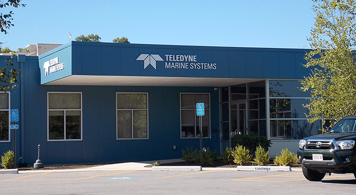 Exterior of TeleDYN Marine Systems building with parking lot and trees nearby.