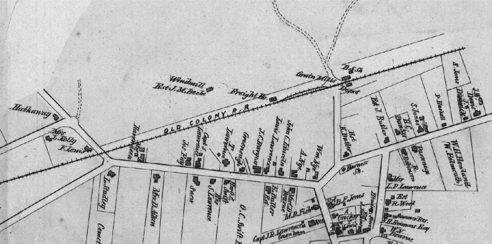 A historical map showing land parcels, roads, and buildings, with handwritten labels and a railroad track running across the top.