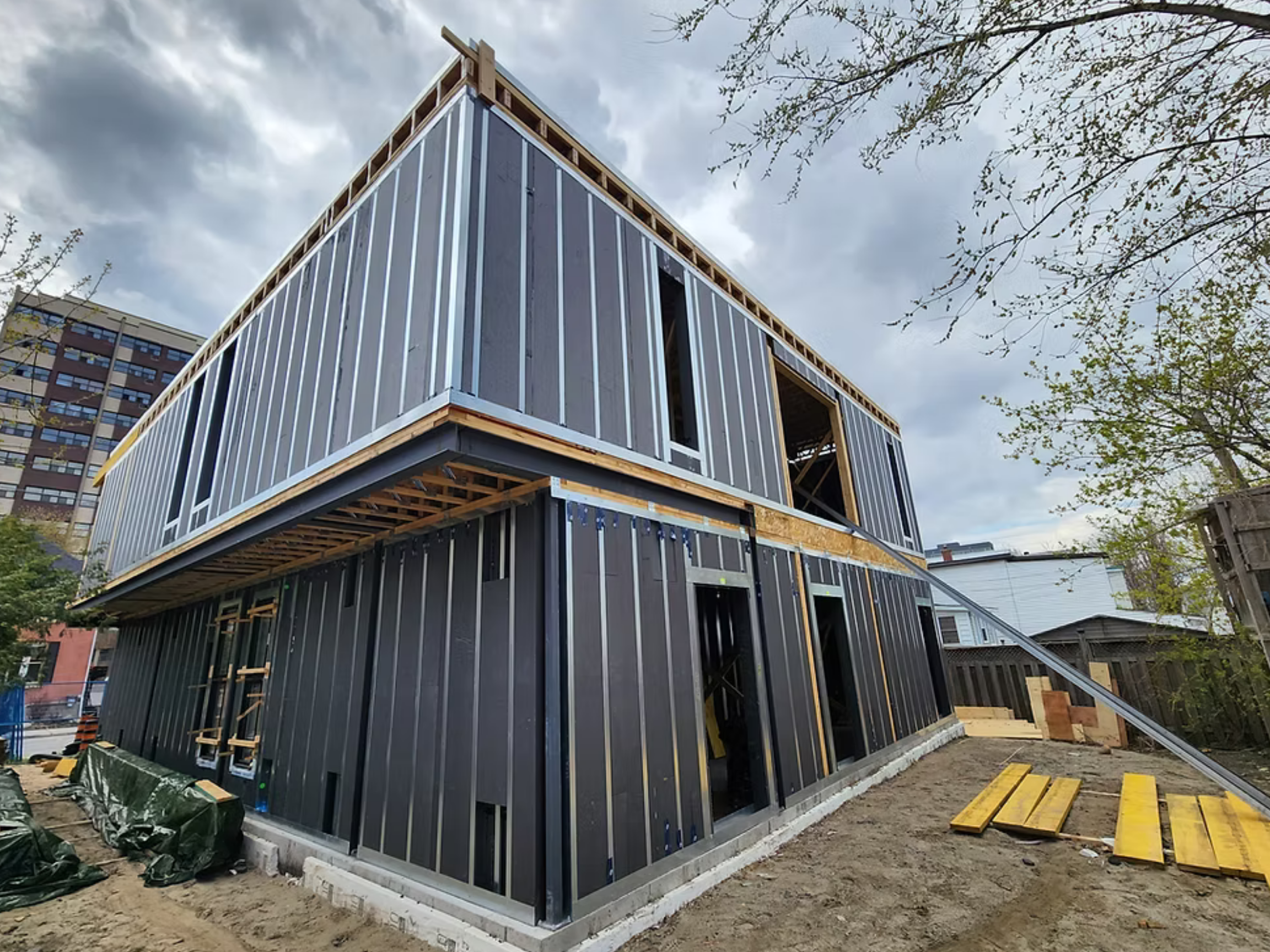 In-progress exterior image of a multi-unit residential infill titled "Grant" using the HARMONIC building envelope.