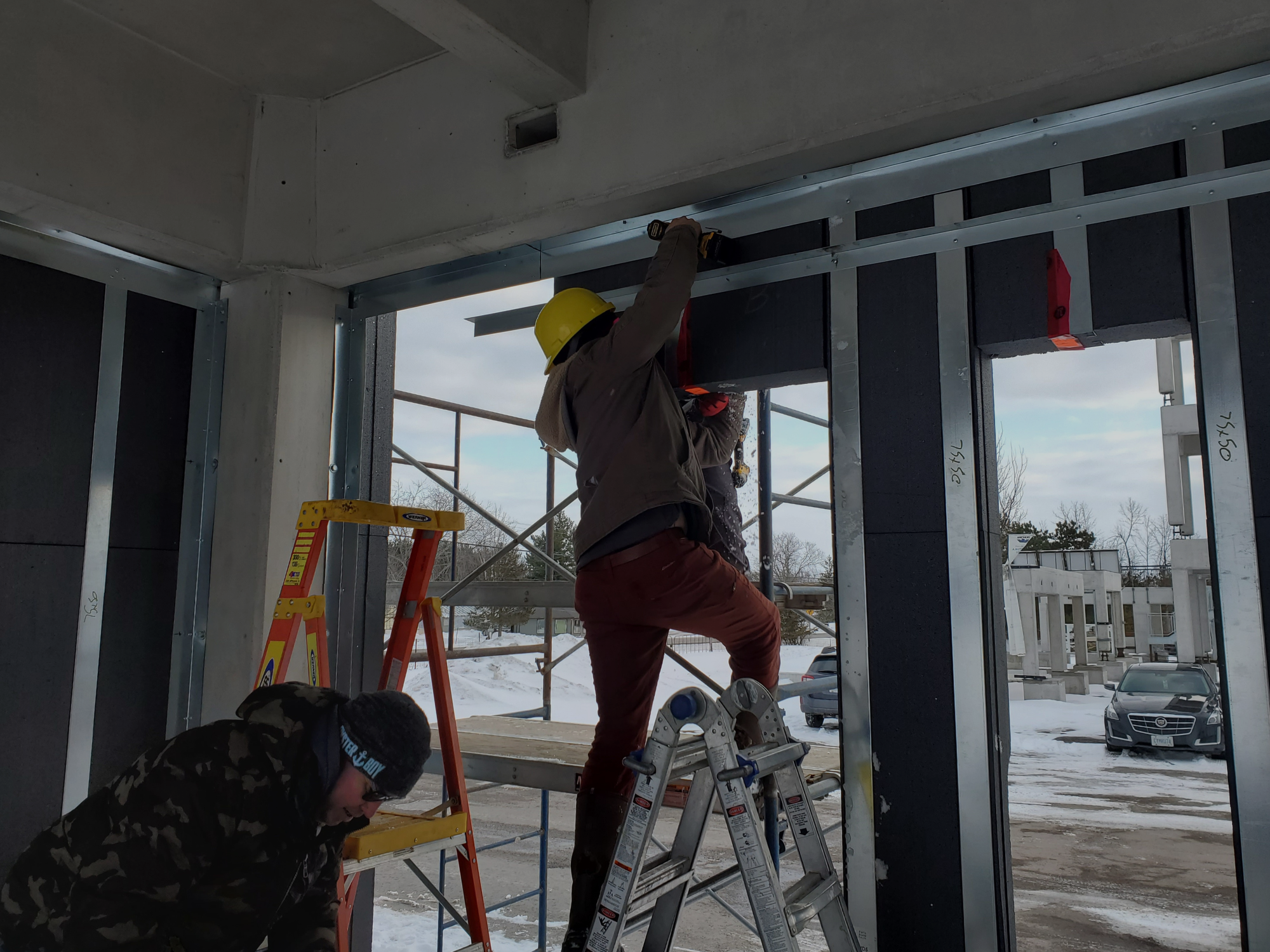 An image of builders inside the HARMONIC building envelope in the winter.