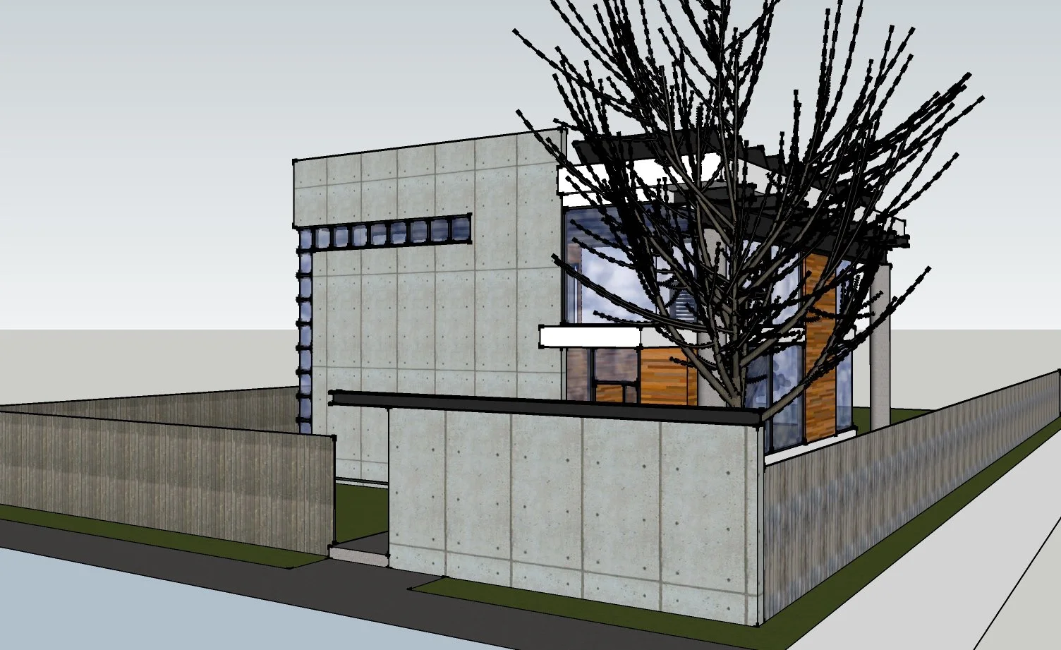 A modern two-story house with concrete and wood exterior, surrounded by a concrete fence, with a large leafless tree in front, and a sidewalk along the street.