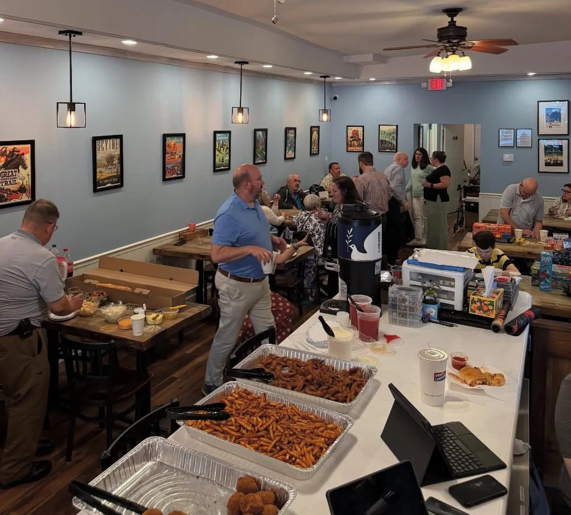 Friends and family gather for a party hosted inside the cafe enjoying food and socializing.