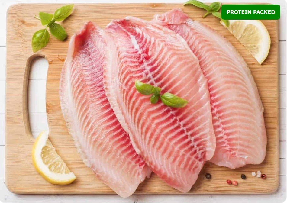 Three pieces of raw fish fillets on a wooden cutting board, garnished with lemon wedges, basil leaves, and peppercorns, labeled as protein packed.
