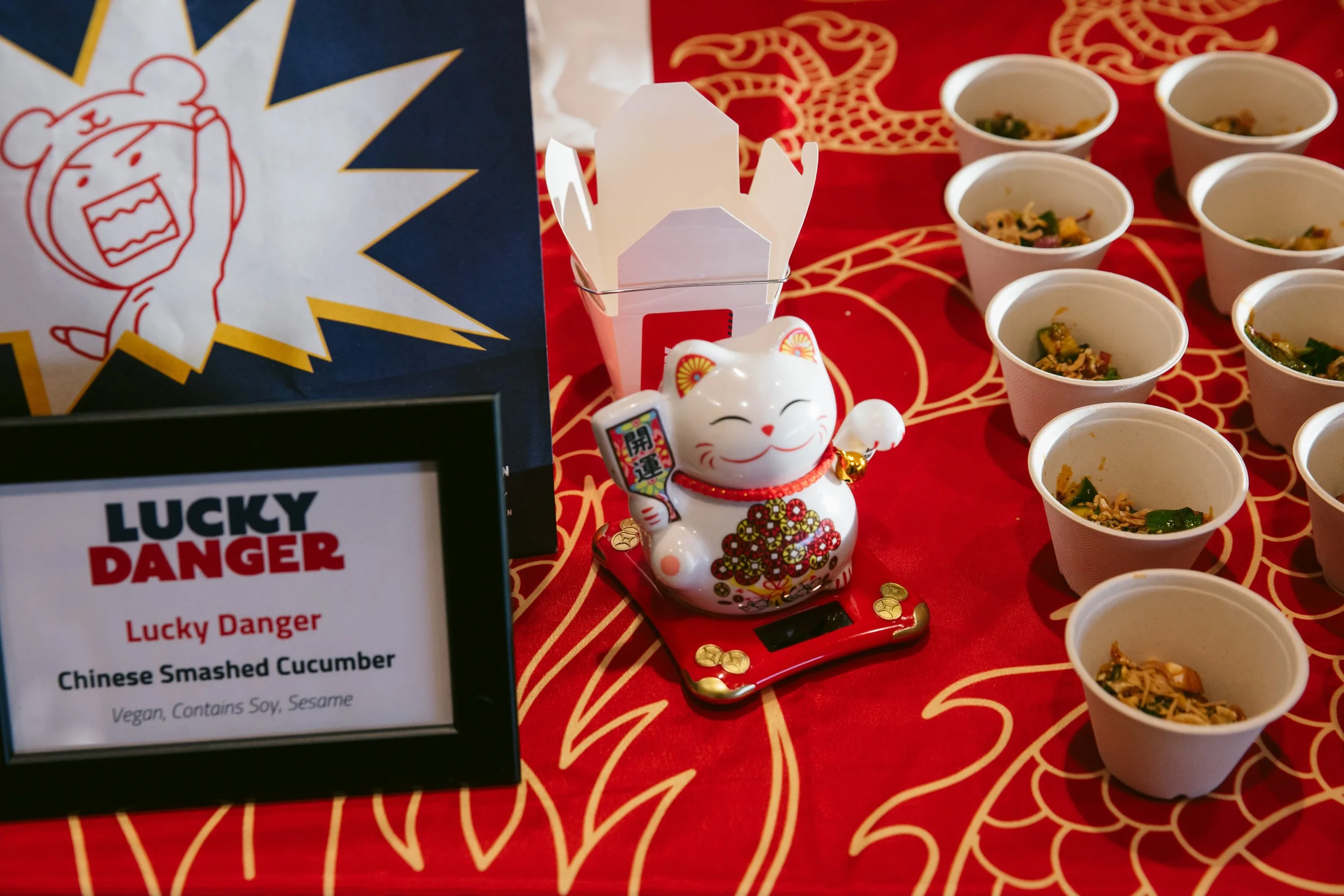 Photo of Lucky Danger restaurant's station at the WE RESCUE 25! fundraiser, featuring samples of Chinese smashed cucumber salad