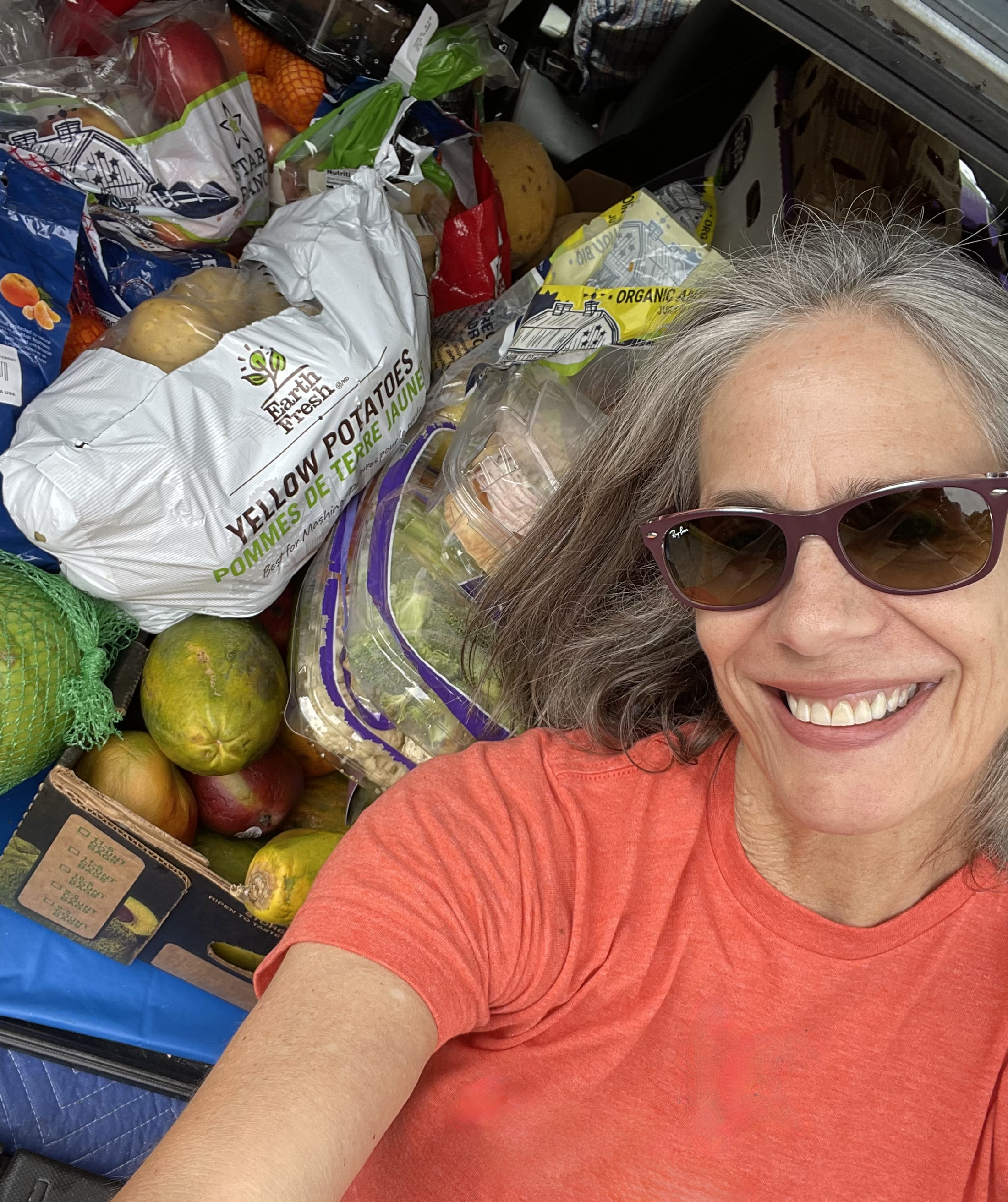 DC Food Rescue, formerly Food Rescue US - DC, founder Kate Urbank smiling with a car full of donated produce.
