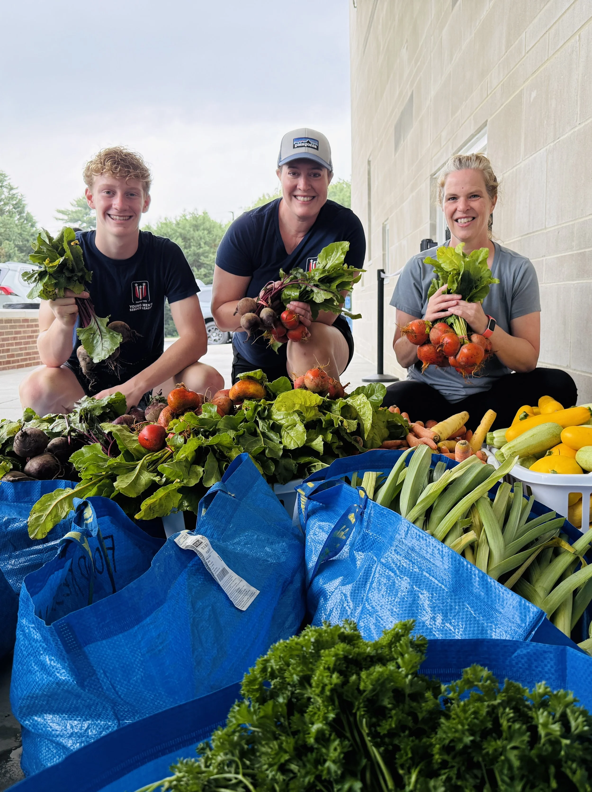 DC Food Rescue volunteers holding fresh vegetables gleaned from a farmers market in Fairfax, Virginia.