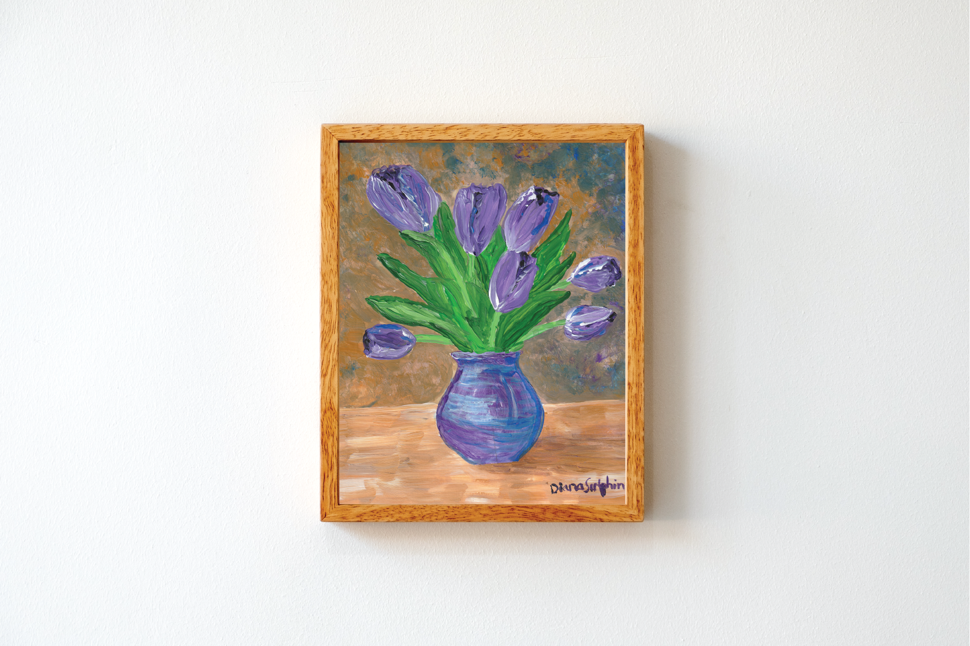 Oil painting of purple tulips in a blue vase on a wooden surface, signed by the artist in the bottom right corner.