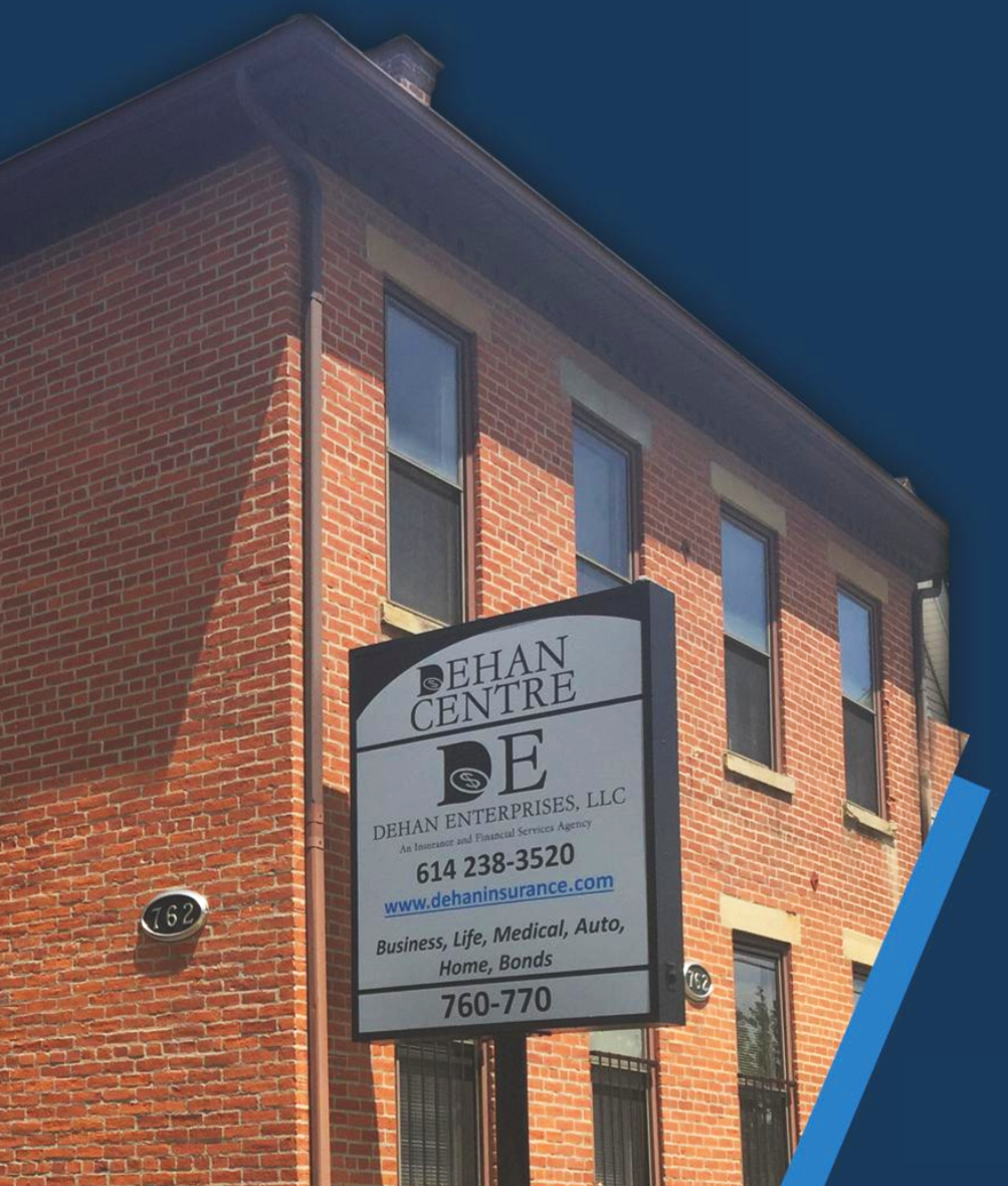 A brick building with tall windows and a sign advertising Dehan Centre, Dehan Enterprises, LLC, an insurance agency offering business, life, medical, auto, home, and bonds insurance. The sign includes phone numbers and a website address.