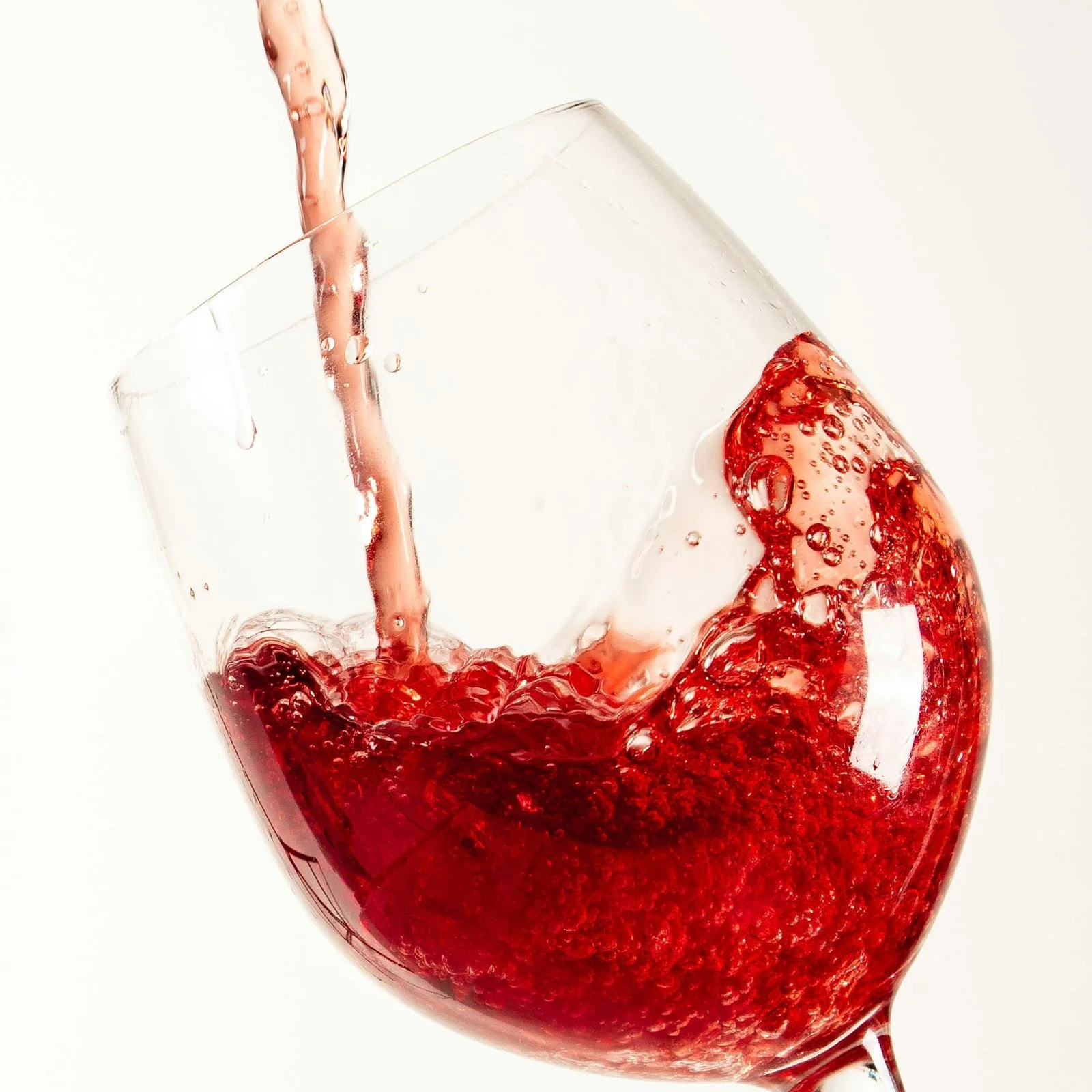 Red natural wine being poured into a wine glass