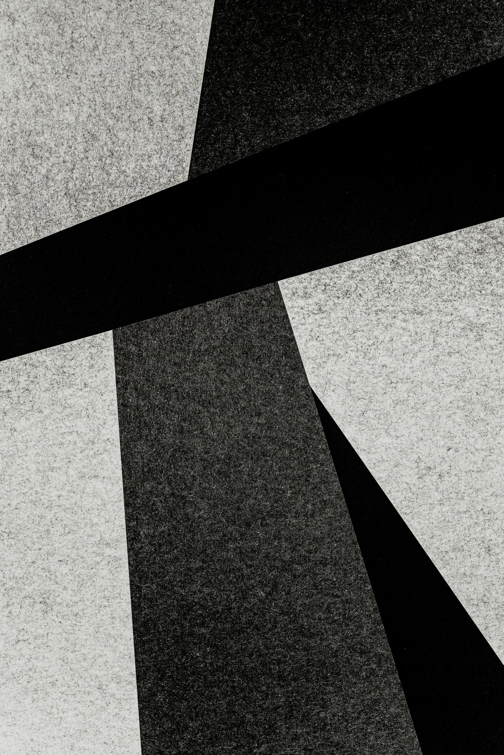 Abstract black and white geometric pattern with sharp angles and textured surfaces.