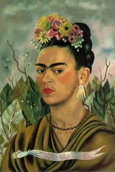 Image of Frida with her face turned at 3/4s, wearing a draped, olive green garment, a necklace of thorns, and flowers across the top of her head.